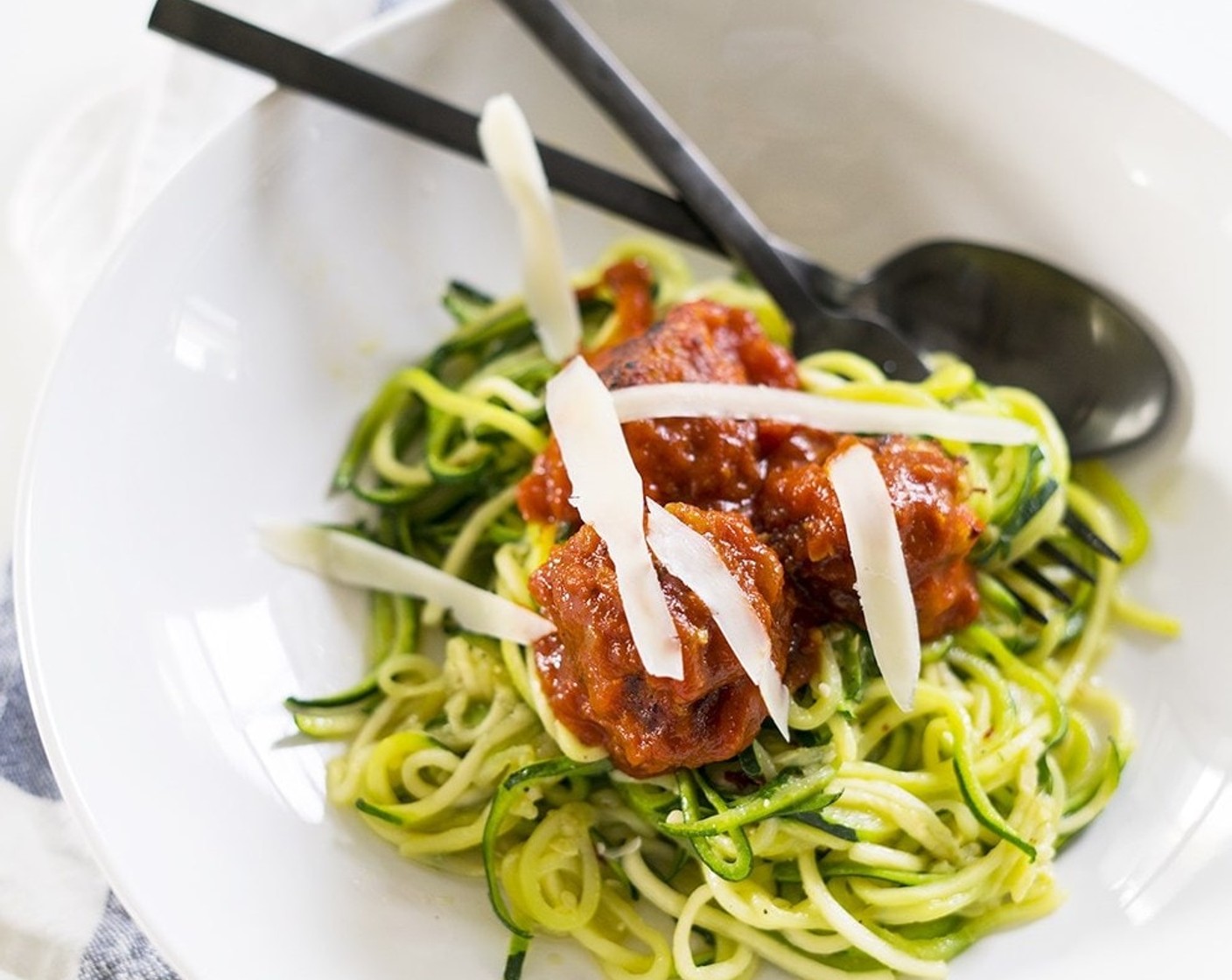 step 8 Transfer zoodles to bowls and generously top with mini meatballs and sauce. Shave fresh parmesan on top. Serve and enjoy!