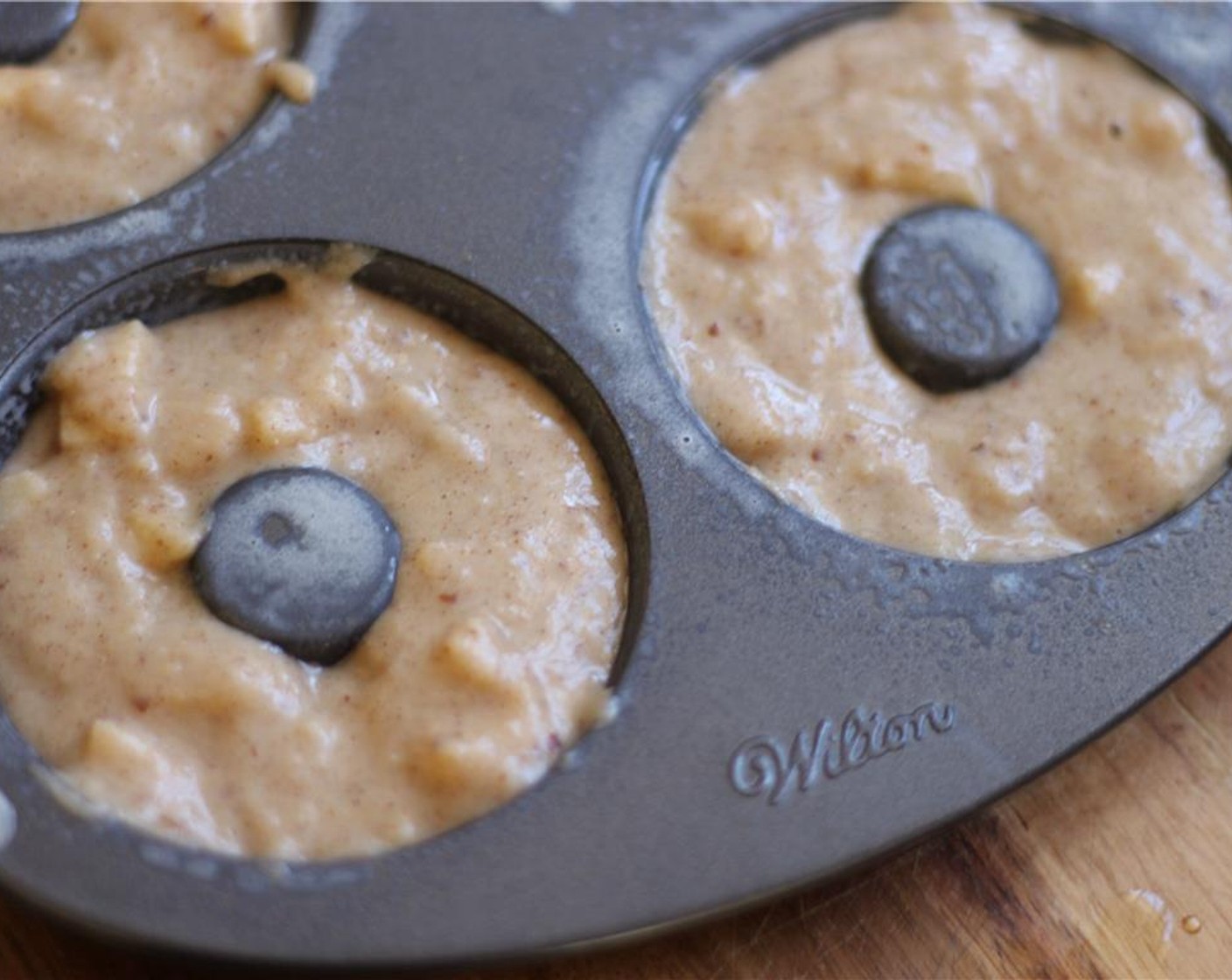 step 7 Spoon the batter into the doughnut molds filling to just below the top of each mold, 1/8 in - 1/4 in from the top. Bake for 18-22 minutes until lightly golden brown around the edges. A toothpick inserted in the center should come out clean.