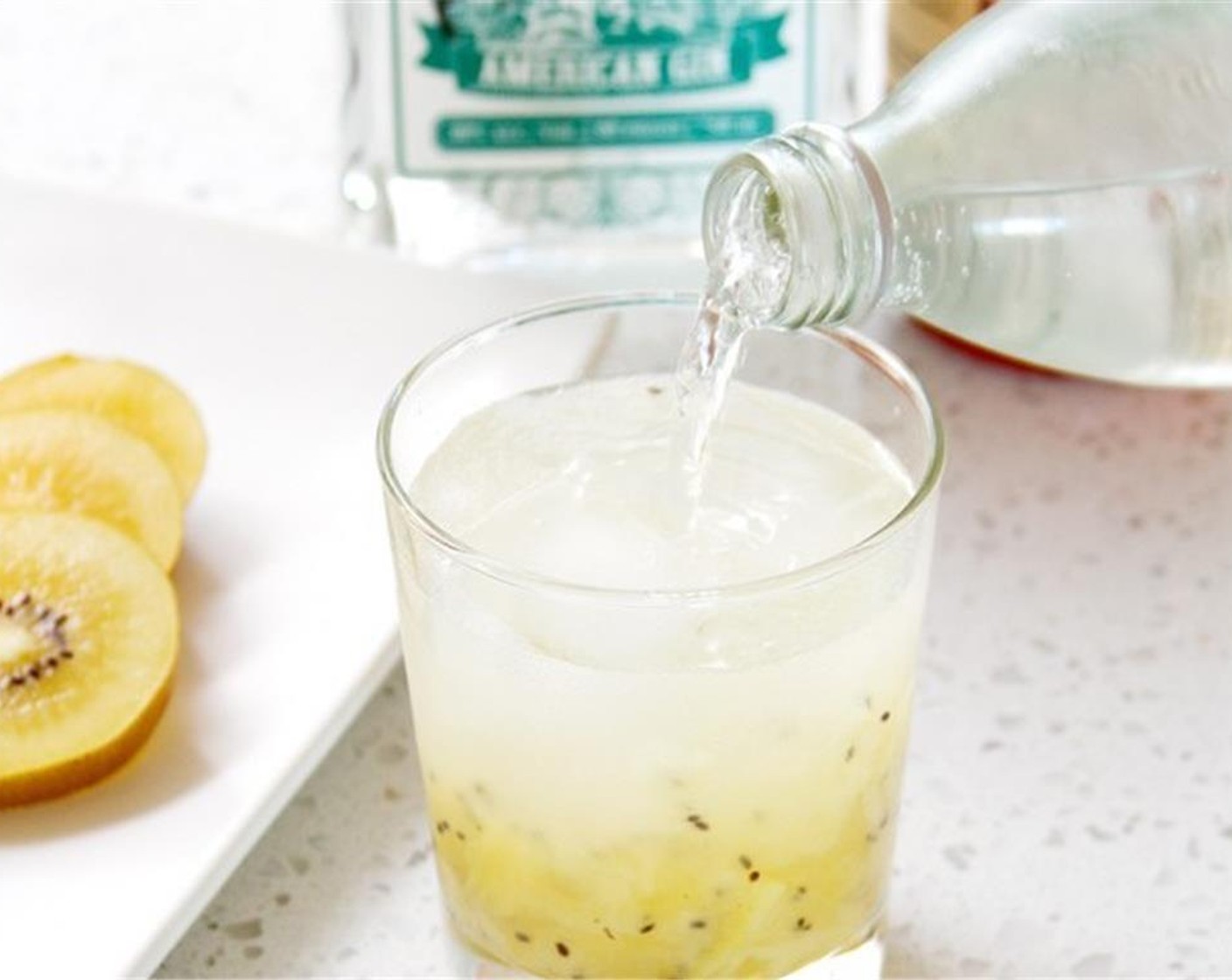 step 2 Add Honey (2 tsp), FEW® American Gin (2 fl oz), and Ice (to taste) to the glass. Fill the glass with Soda Water (to taste) and stir to combine.