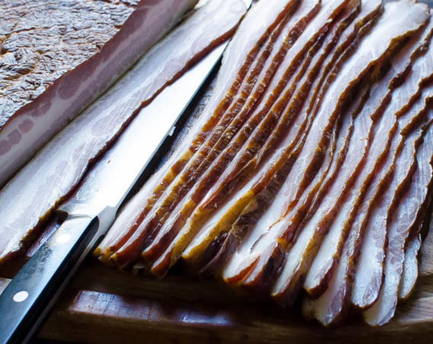 step 12 Use a long, thin, sharp knife to slice the bacon. Lay the slices on the wire rack next to each other, but not touching.