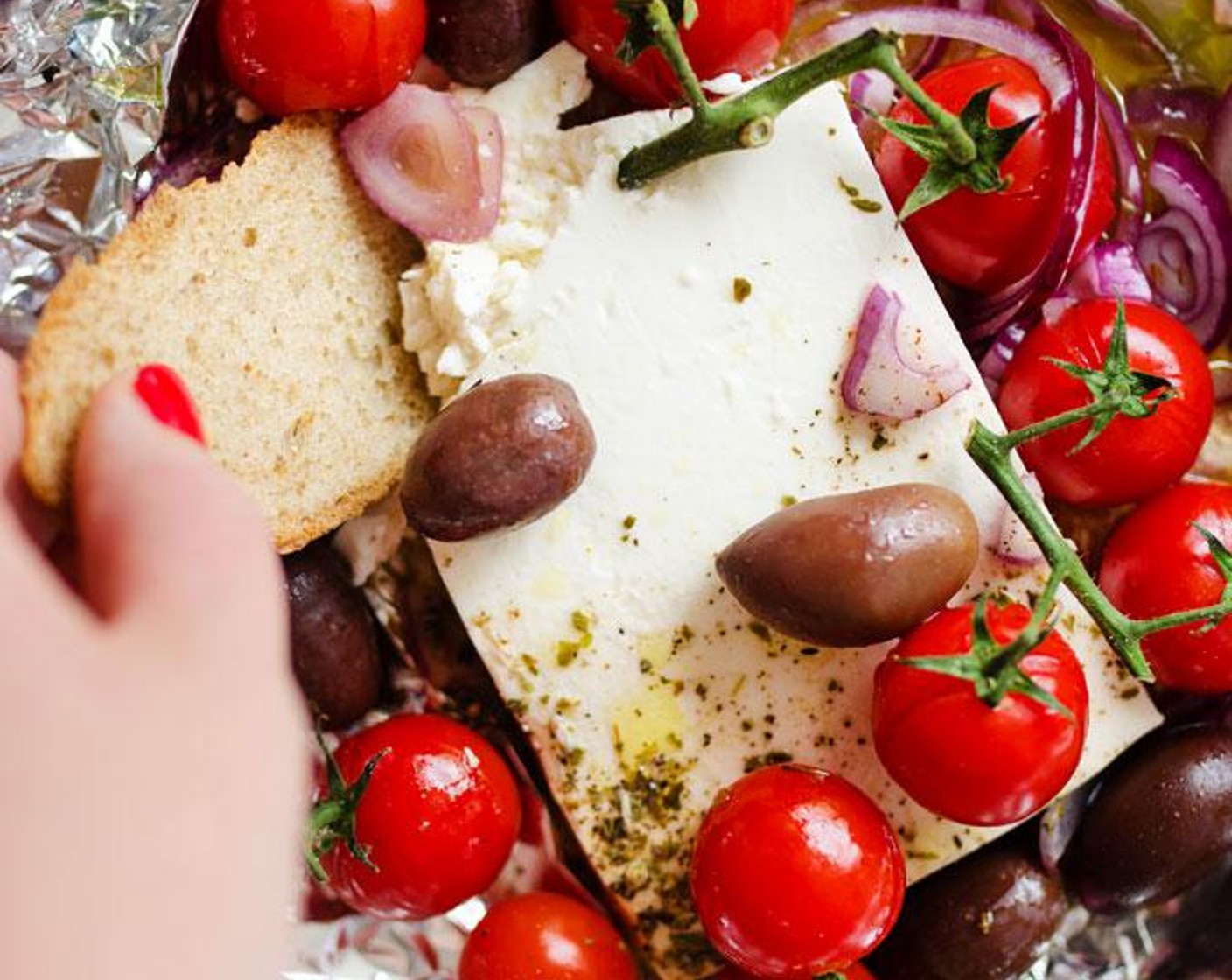 step 2 Set Feta Cheese (1 1/3 cups) in the center of a large sheet of aluminum foil. Drizzle with Olive Oil (2 Tbsp) and toss in the Olives (6), Cherry Tomatoes (10), Red Onion (1/4 cup), Ground Black Pepper (to taste) and Fresh Oregano (to taste).