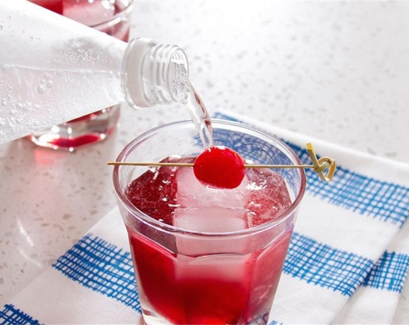 step 1 In a large glass, combine Pomegranate Juice (1/2 cup), Grenadine Syrup (1 splash), and Vodka (1/2 cup). Stir to combine, and then pour into two glasses over ice. Top each glass with half of the Sparkling Lemon Water (1/2 cup).