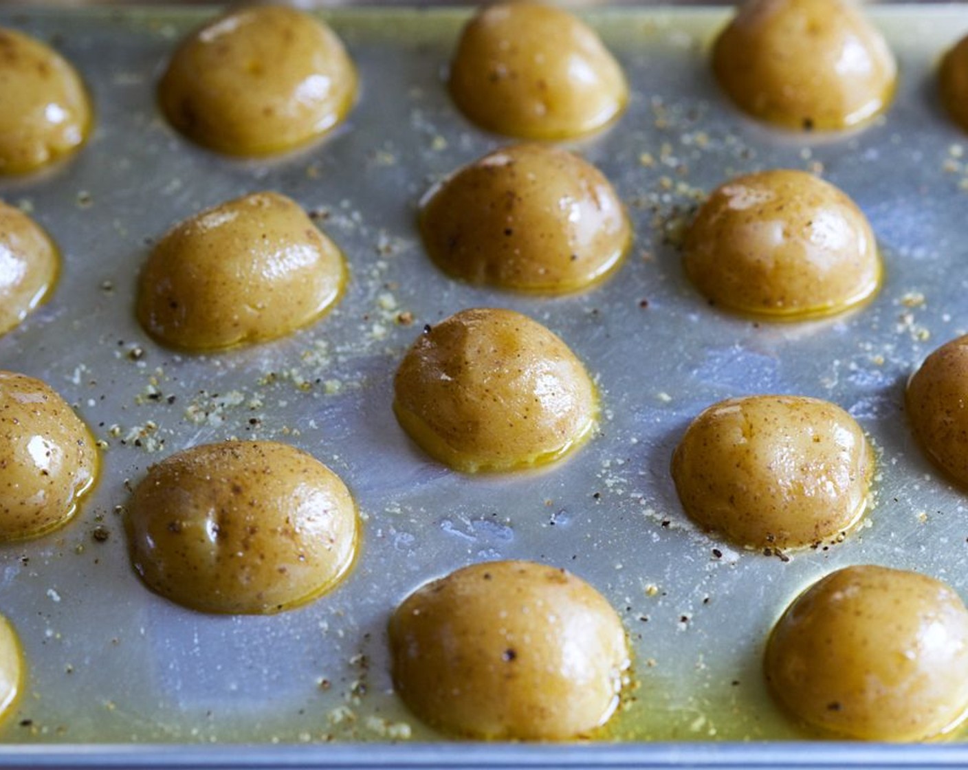 step 6 Drizzle Olive Oil (4 Tbsp) all over the potatoes, season with Kosher Salt (to taste) and Freshly Ground Black Pepper (to taste), and toss to coat. Place them cut side down again, and return to the 500 degree F (260 degrees C) oven, uncovered, for 20-25 minutes.