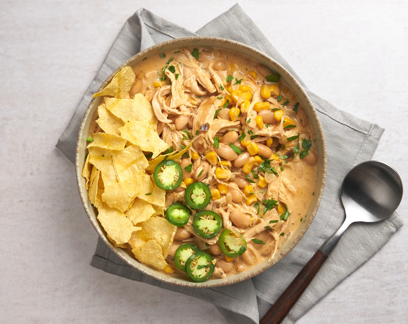 step 6 Transfer to a serving bowl and top with Shredded Parmesan Cheese (to taste), Avocados (to taste), Fresh Cilantro (to taste), Tortilla Chips (to taste), and Jalapeño Peppers (to taste). Enjoy warm!