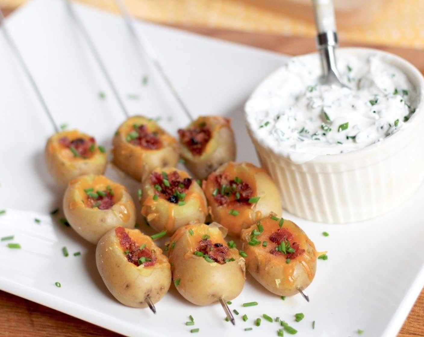 step 7 Transfer the Mini-Stuffed Baked Potato Kababs to a serving plate. Top each with a dollop of the chive sour cream or serve it on the side.