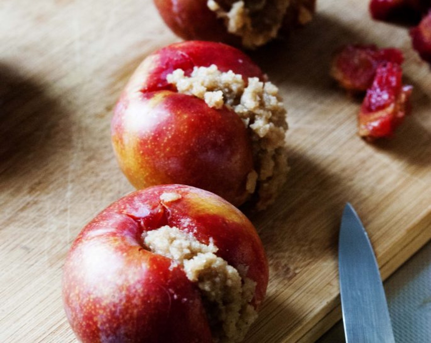 step 15 Next, fill the plums with the crumble mixture using a small spoon.