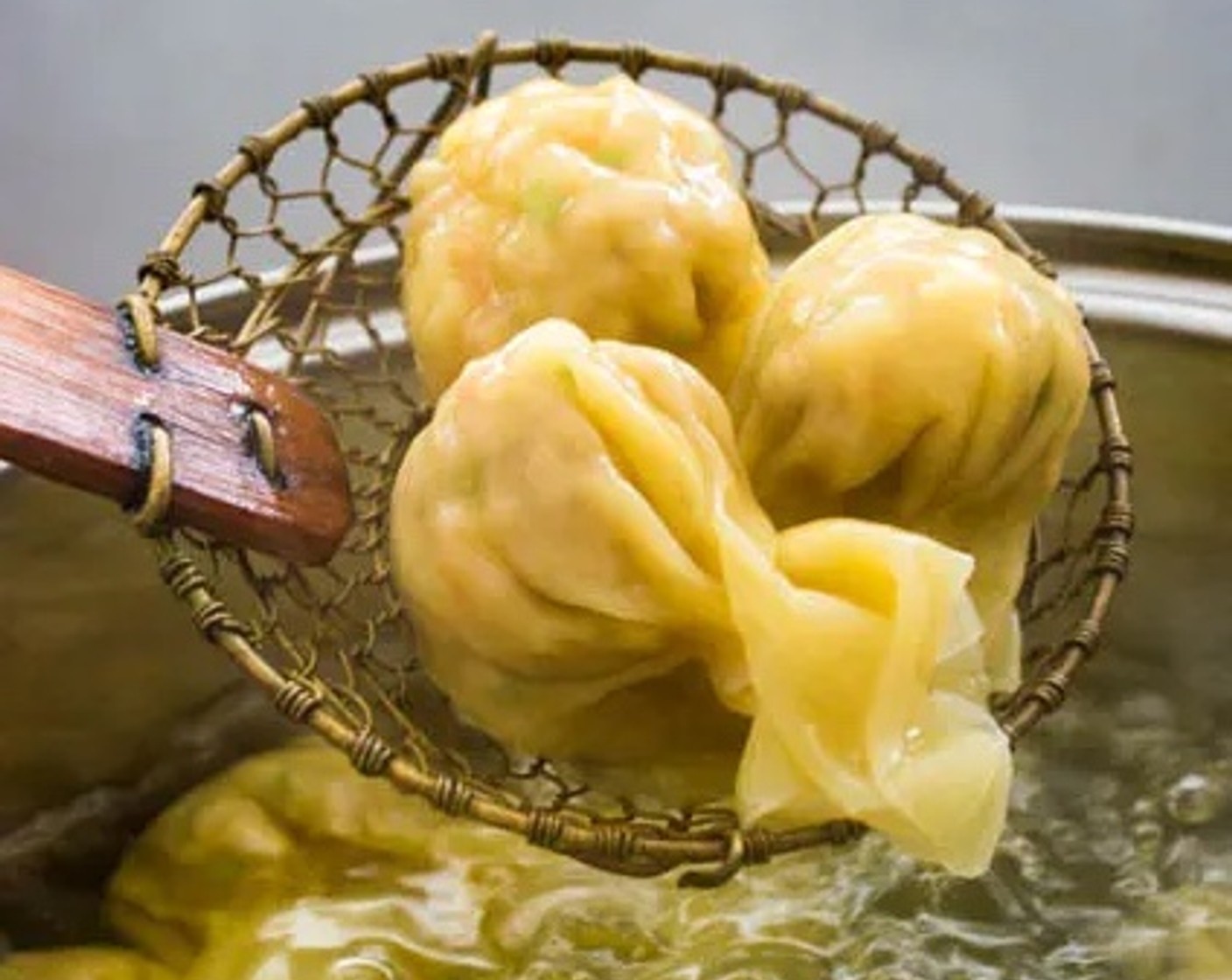 step 5 Remove the cooked wontons from the water using a spider skimmer, place them onto a plate and drizzle a bit of Sesame Oil on them.