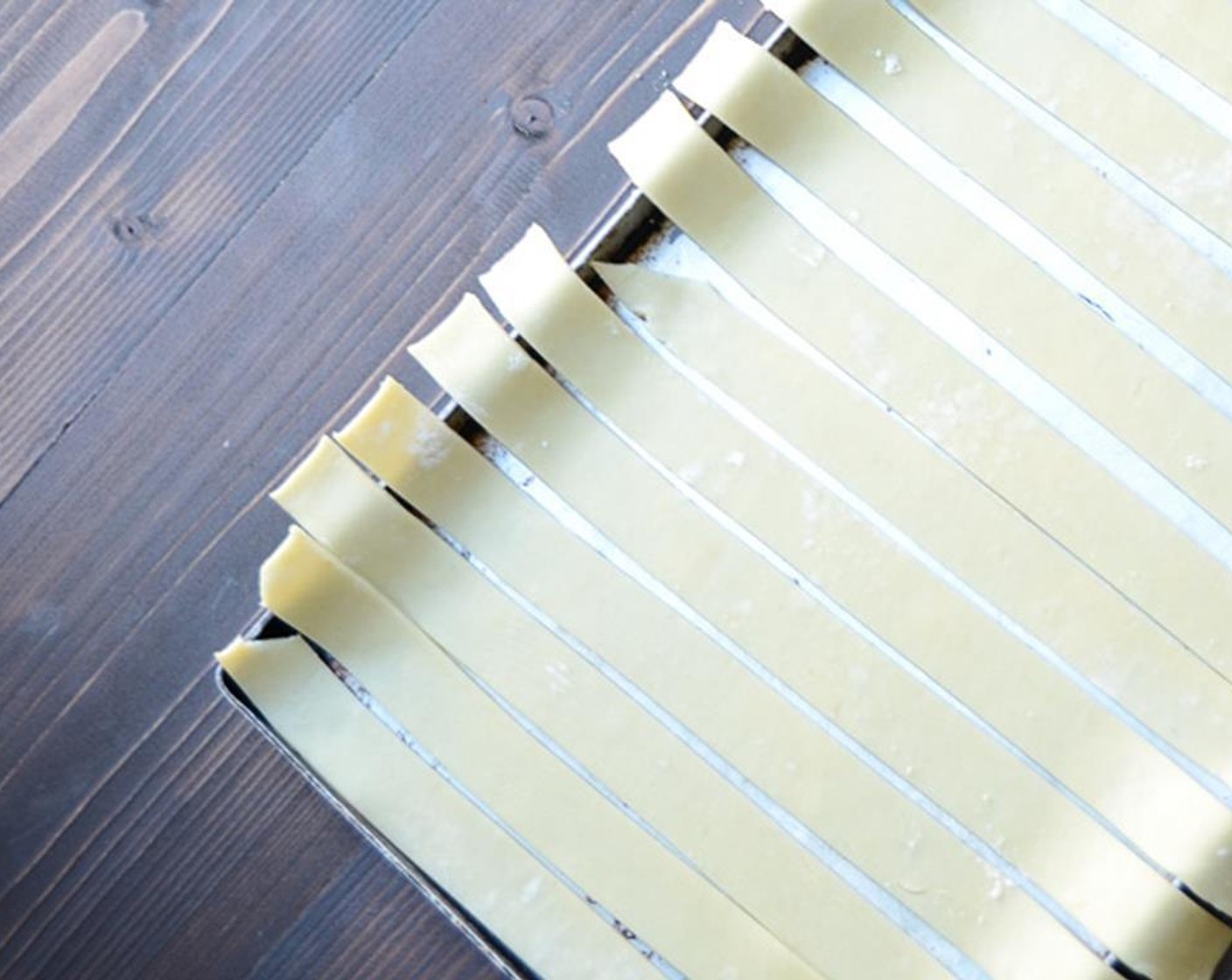 step 3 Roll out the other disc of Pie Crust into a rectangle, roughly 12x10". Trim rounded edges and use a ruler to score and slice into even 10" long strips, each about 1" wide. Separate the strips on a cookie sheet and freeze until firm, about 30 minutes.