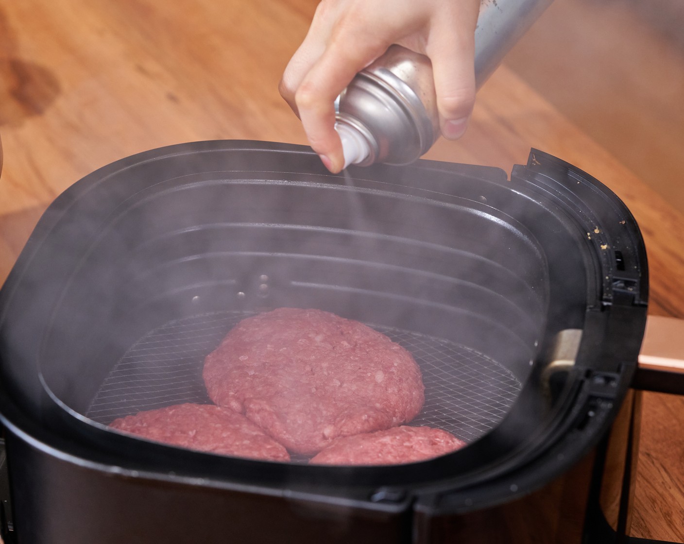 step 4 Spray the air fryer basket with Nonstick Cooking Spray (as needed). Add patties to the basket and spray the tops with oil. Cook for 5 minutes.