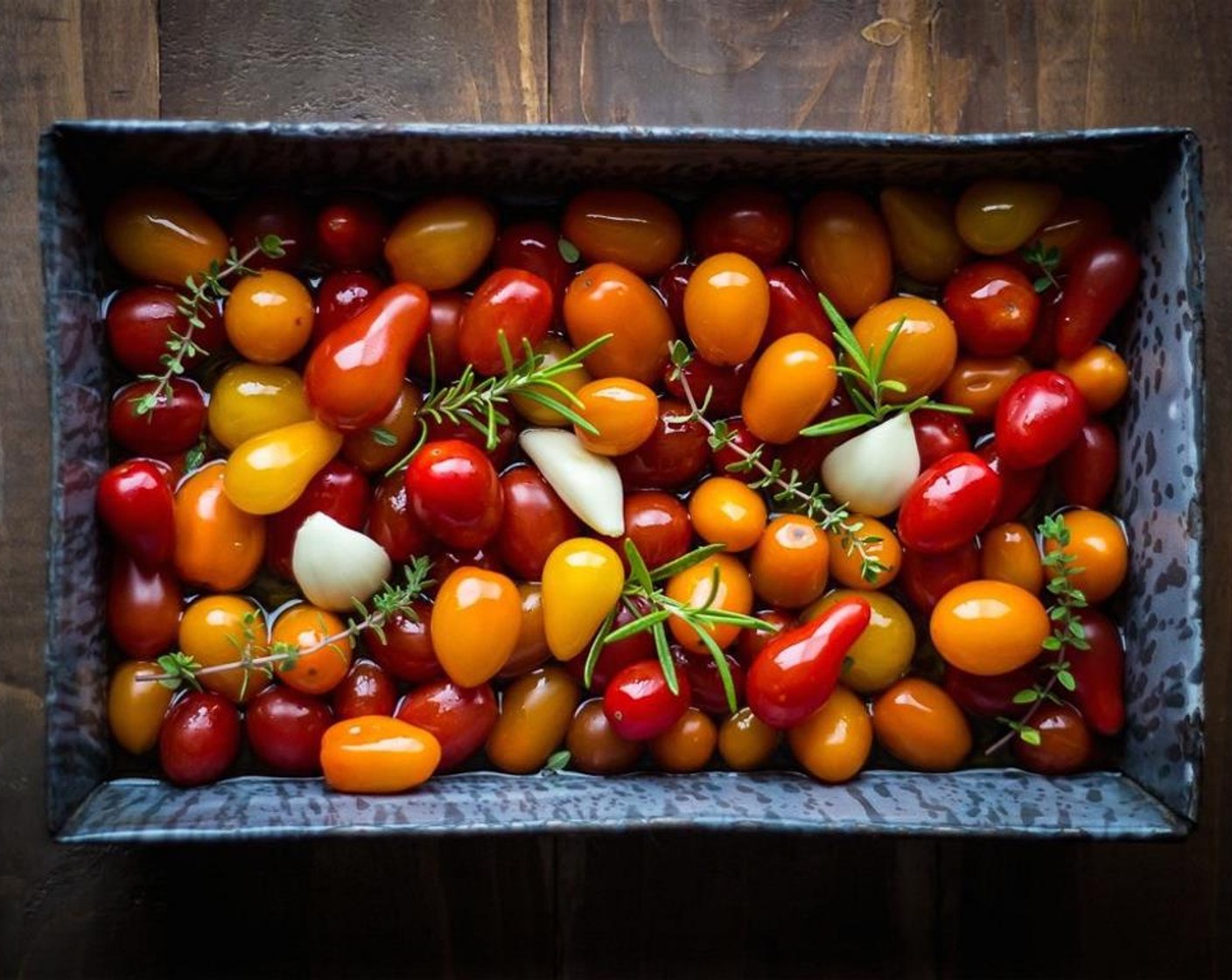 step 2 Then, fill a baking pan with the Cherry Tomatoes (3 cups). Add the Extra-Virgin Olive Oil (1/2 cup), Garlic (3 cloves), Fresh Rosemary (3 sprigs), and Fresh Thyme (5 sprigs).