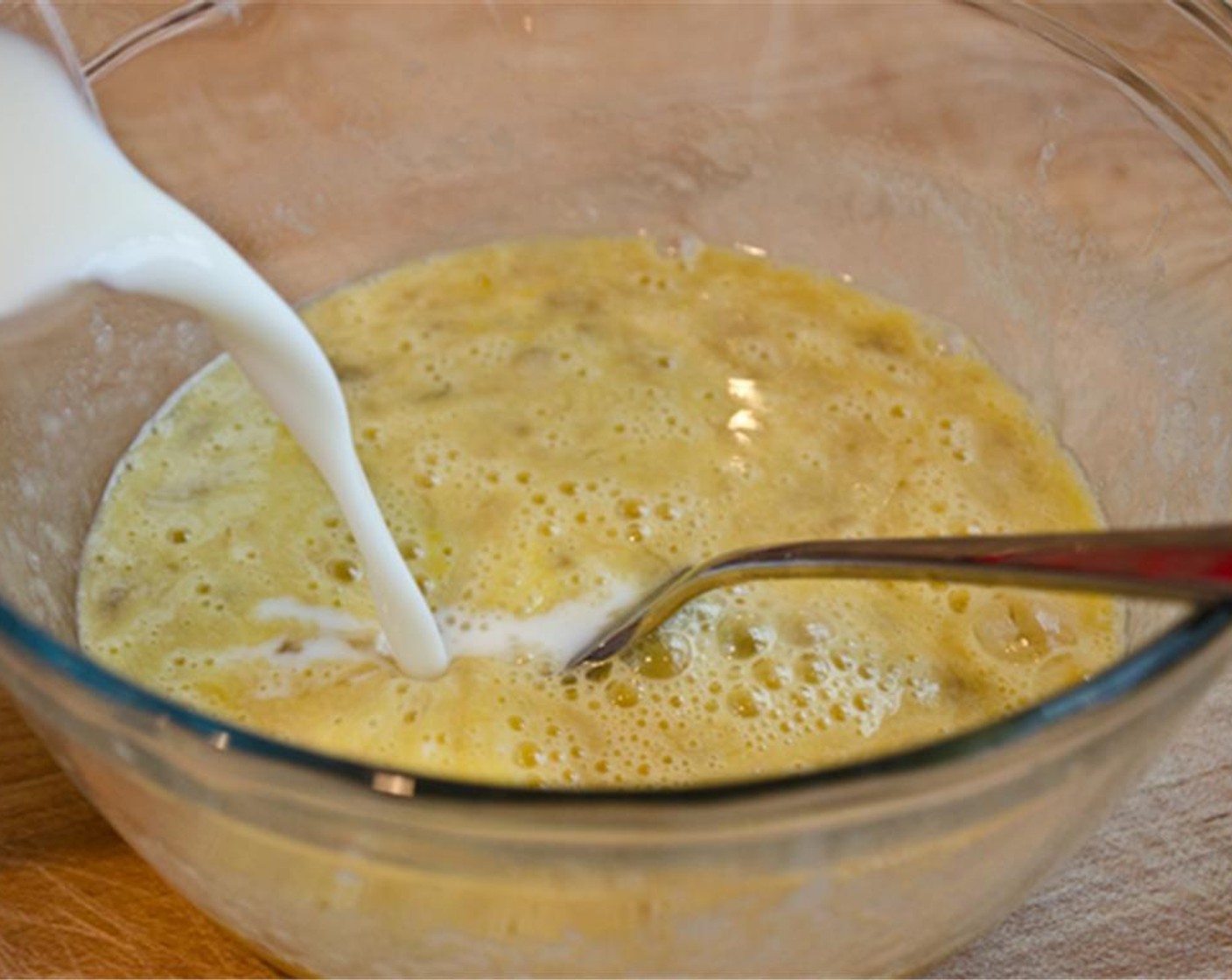 step 2 In another small bowl, mash the Banana (1) with a fork until almost smooth. Whisk in the whole large Eggs (2), then add the 1% Low Fat Milk (1 cup) and Vanilla Extract (1/2 tsp) and whisk until well blended.