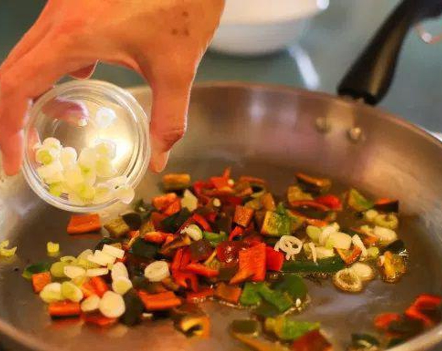 step 2 Heat a large skillet on medium heat. Add Extra-Virgin Olive Oil (2 Tbsp). Add Poblano Peppers (2) and Scallion (1/4 cup) to skillet. Add Ground Cumin (1 tsp) and stir in.