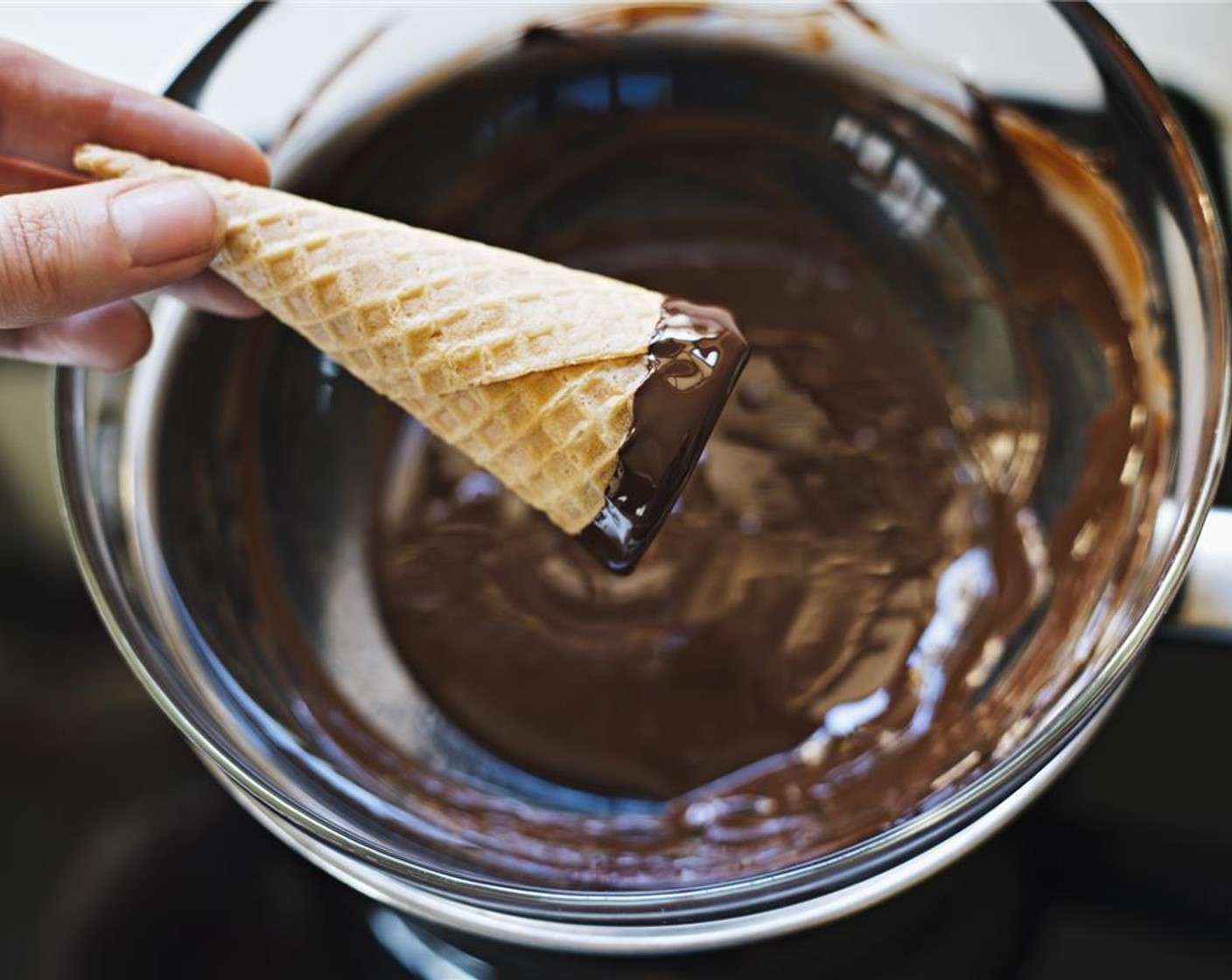 step 3 Dip the rim of each of the Waffle Cones (12) in the melted dark chocolate, making sure to evenly coat.