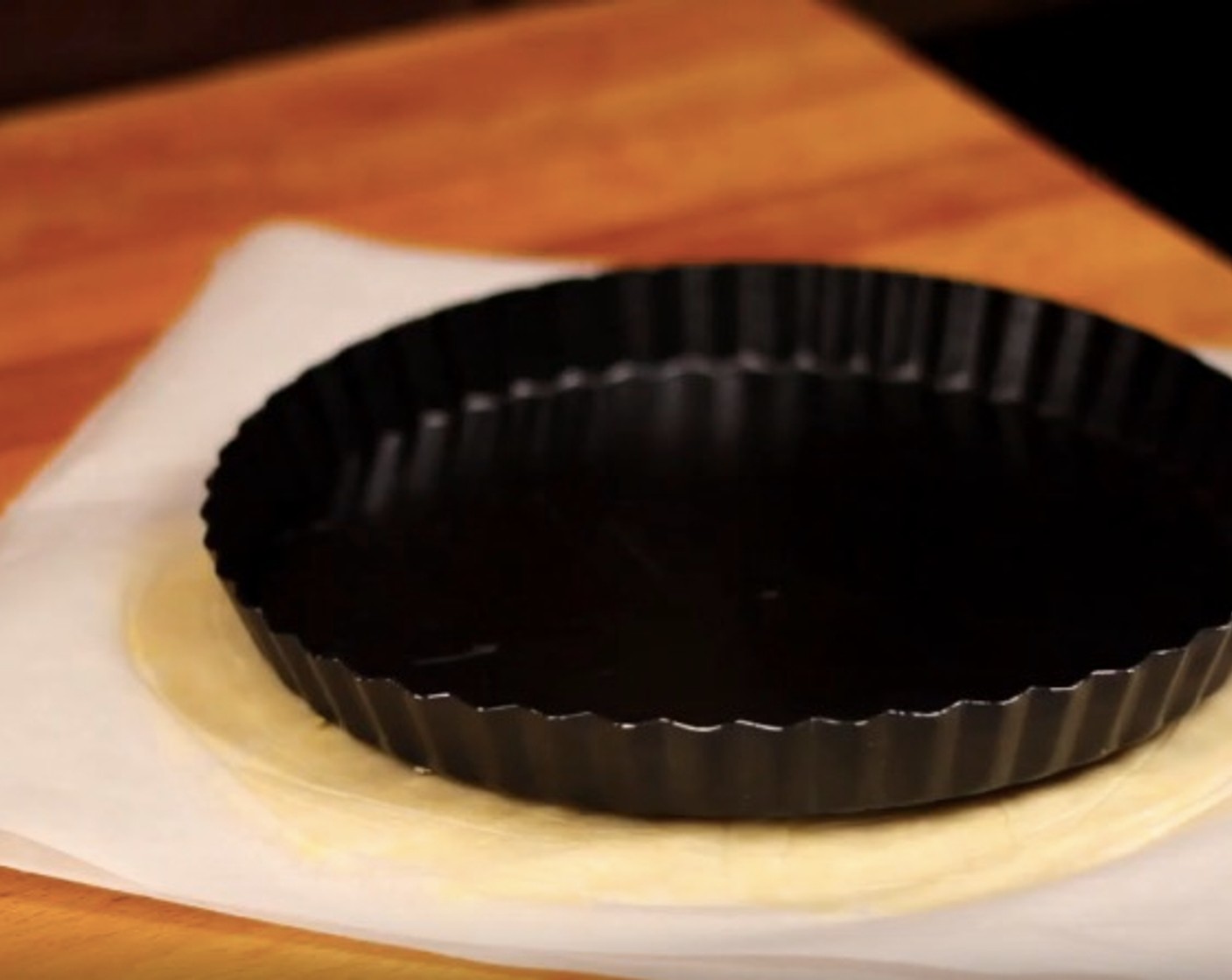 step 9 Take one of your chilled dough and roll it out between two parchment paper. Make sure to roll out about an inch larger than the tart pan itself. Let it chill in the fridge for 10 minutes to firm up before pressing it into the tart pan.