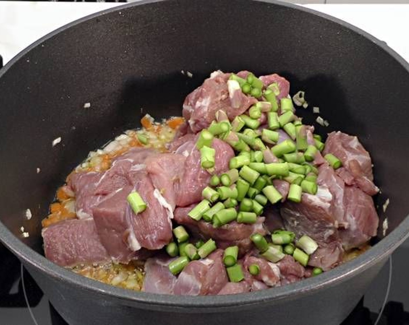 step 2 Once the onion starts turning translucent place the pieces of Boneless Leg of Lamb (2) in the pot along with the Asparagus (1 handful).