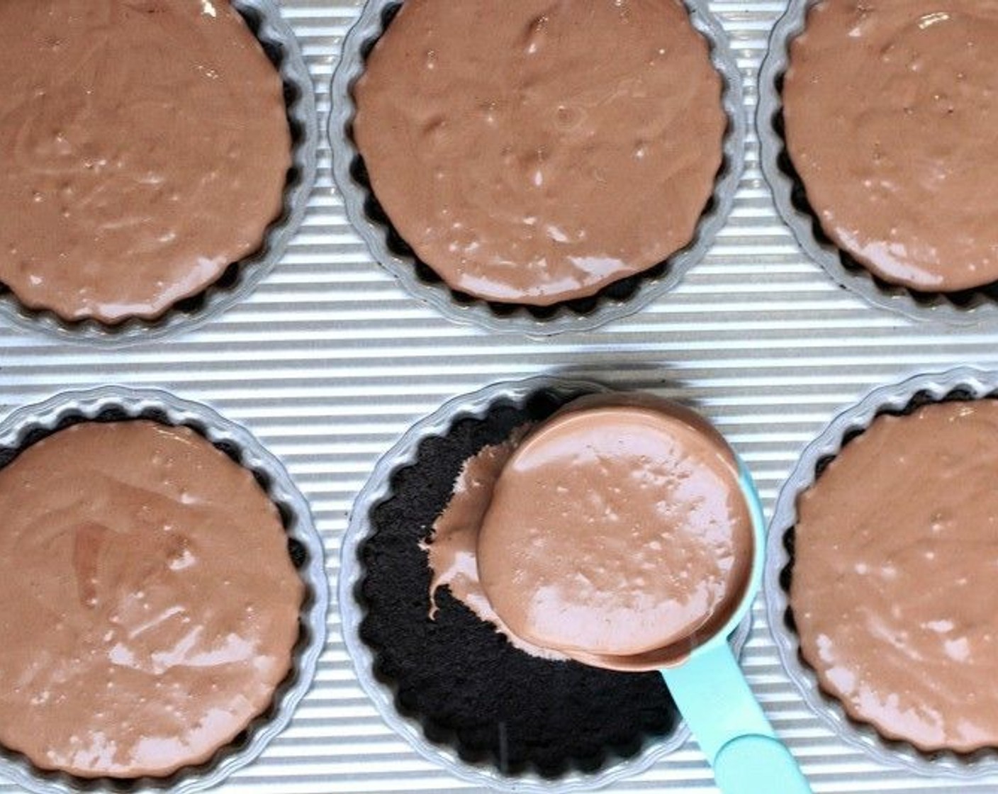 step 9 Spoon Chocolate Cheesecake Filling evenly into individual tart shells and smooth top. Transfer to the freezer.