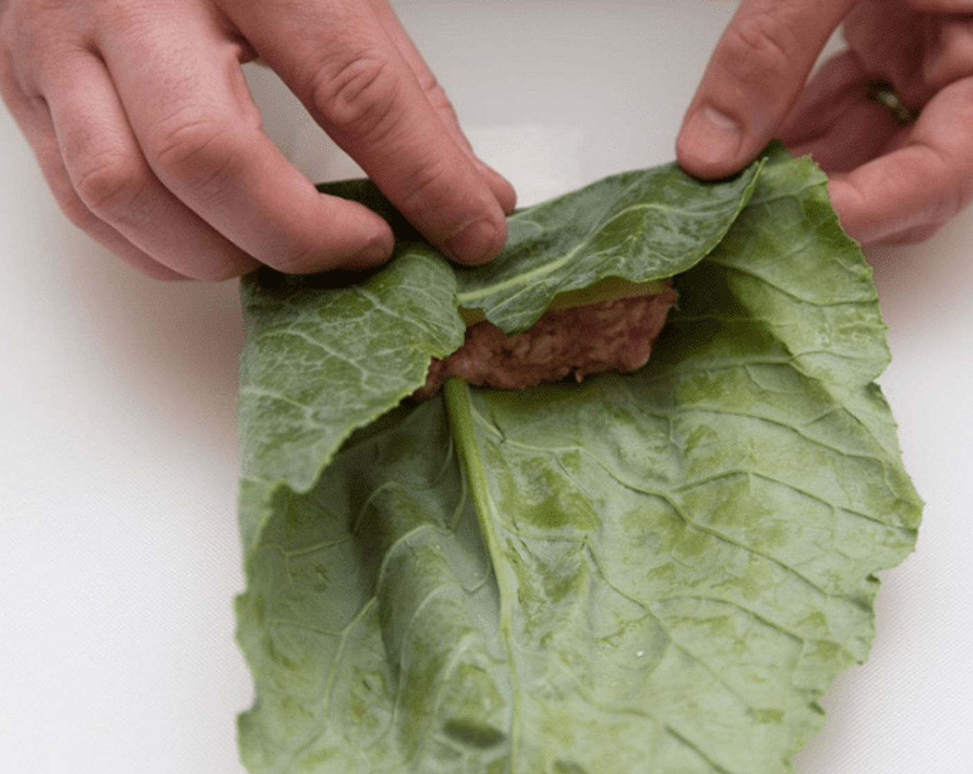 step 8 Fold the stem end of the leaf over the filling, then fold both sides in and roll until the top of the leaf is under the stuffed leaf - this will keep it from unrolling. Repeat with remaining leaves, filling and a few apple slices in each packet.