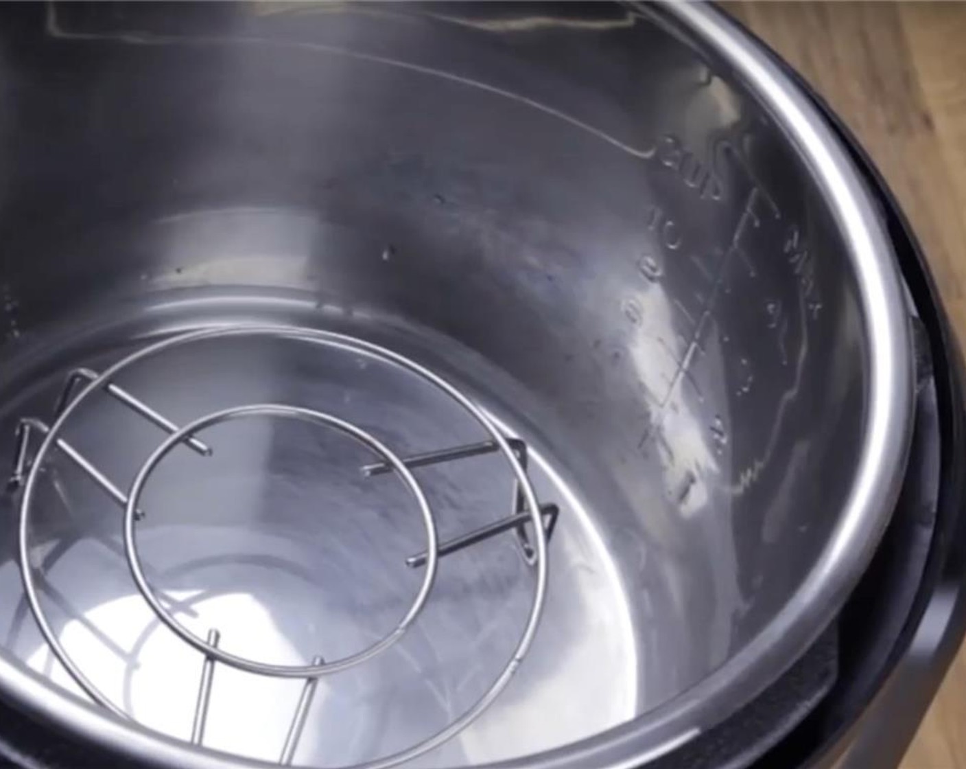 step 10 Place a steamer rack and pour one cup of water into an electric pressure cooker. Place the bamboo steamer filled with Shumai into the pressure cooker. Close lid and cook at High Pressure for 3 minutes.