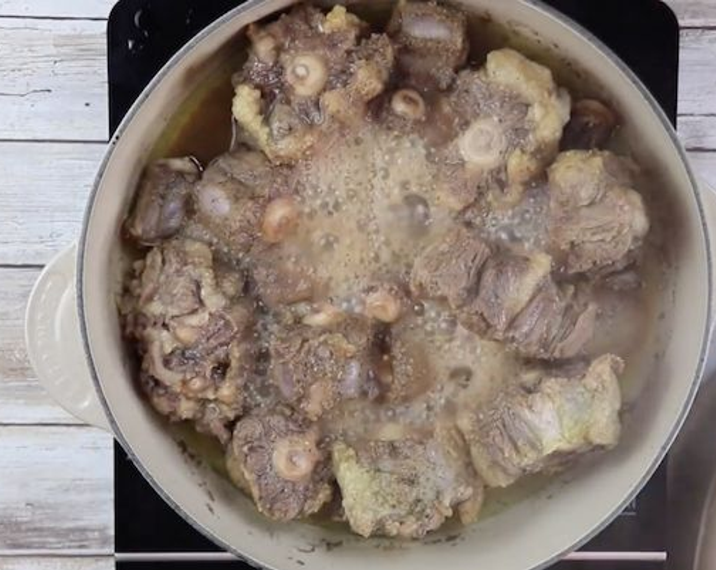 step 2 At medium to low heat, in a Dutch oven deep pot cook the oxtails. Heat Corn Oil (1/3 cup) over low to medium heat and add oxtails. Cover and stir frequently. If the oxtails are thick, it will take about 2-3 hours to cook until tender. Add a bit of water if you feel they are drying out.