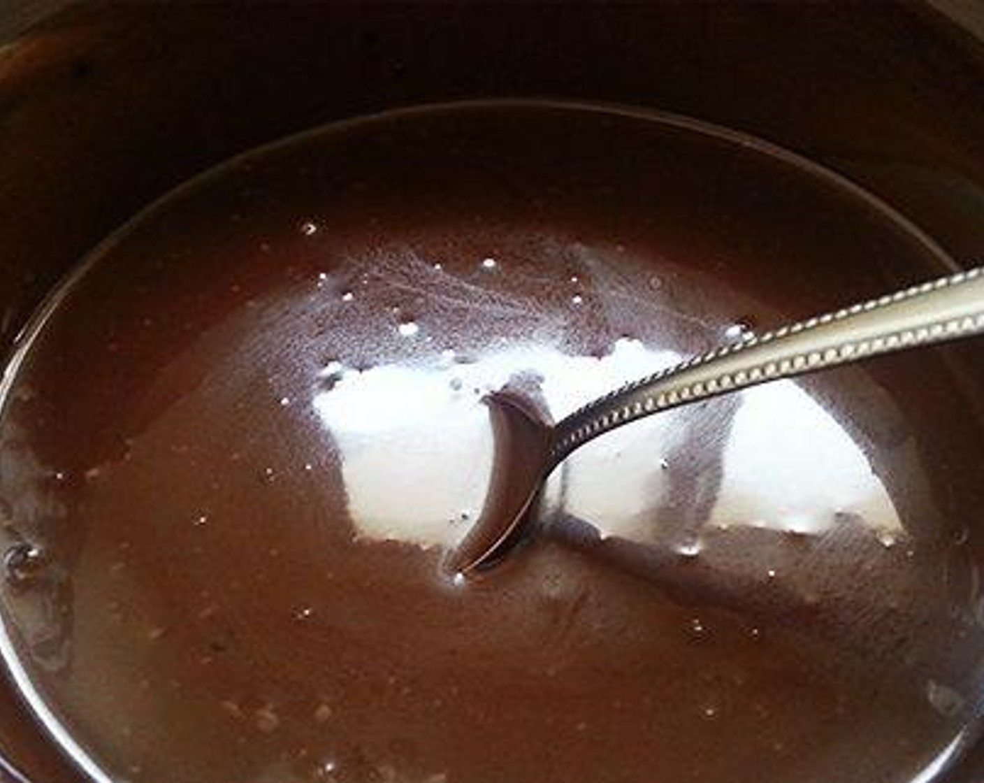 step 6 For the ganache: Pour the Fresh Cream (3/4 cup) to a pan and heat it well. You can see small bubbles formed. Now pour this hot cream over the chopped Dark Chocolate (1 cup) and keep aside for some time. Now mix the chocolate and cream until well combined and becomes smooth. Let it cool well to a spreadable consistency.