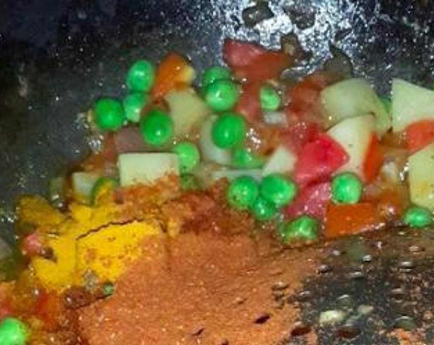 step 6 Now add the Potato (1), Carrot (1), Bell Peppers (2 Tbsp) and Green Peas (1/2 cup). Saute for few minutes and then add Tomatoes (2), stir and add the Ground Turmeric (1/4 tsp), Kashmiri Red Chili Powder (1/4 tsp), Garam Masala (1/4 tsp), Pav Bhaji Masala (1/4 tsp) and salt.