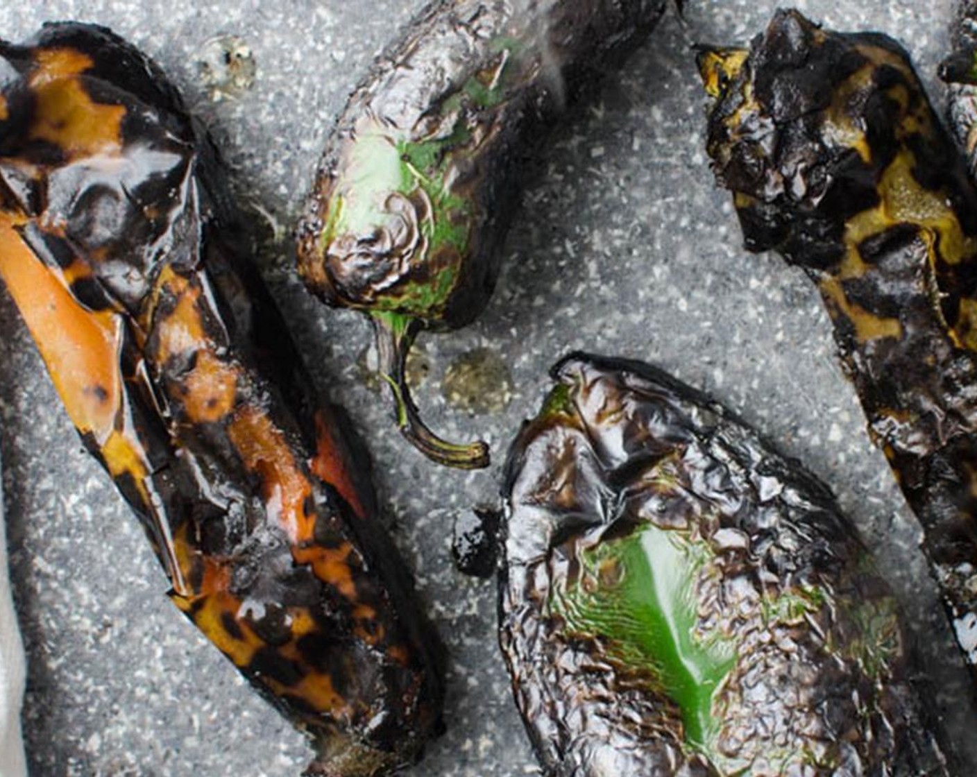 step 1 Preheat the grill to 450 degrees F (230 degrees C) and place the Poblano Peppers (2), Jalapeño Pepper (1), and Hatch Chili Peppers (3) directly on the grates. Cook until the peppers are blackened and blistered all over. Transfer to a bowl and cover with plastic wrap until cool enough to handle.