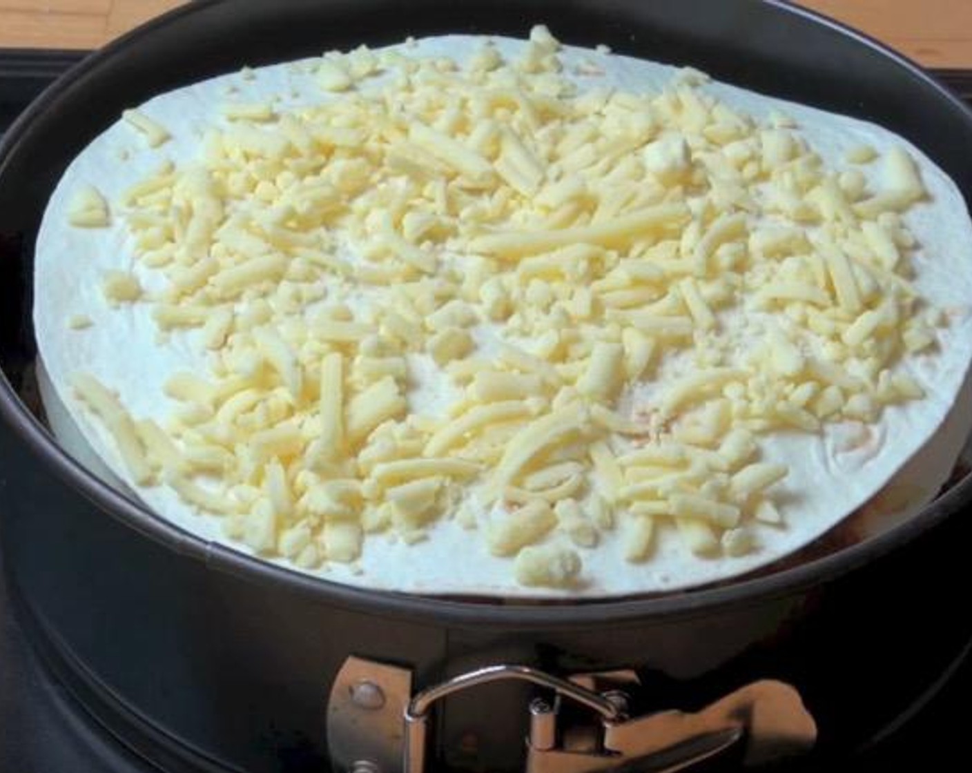 step 6 In a 20-centimeter springform tin, layer one of the Tortillas (4). Spread 1/3 of the beef mixture over the tortilla and sprinkle with 1/4 of the Cheddar Cheese (2 cups). Repeat the same layers until all ingredients are used up.