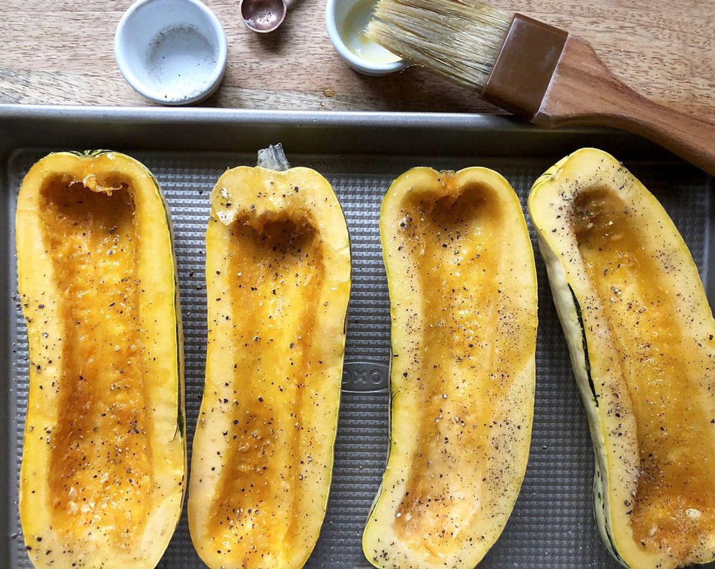 step 2 Brush cut sides of Delicata Squash (2) evenly with Olive Oil (1/2 Tbsp). Sprinkle with the Salt (1/4 tsp) and Freshly Ground Black Pepper (1/4 tsp). Place cut sides up on a large baking sheet. Roast for 30 minutes.