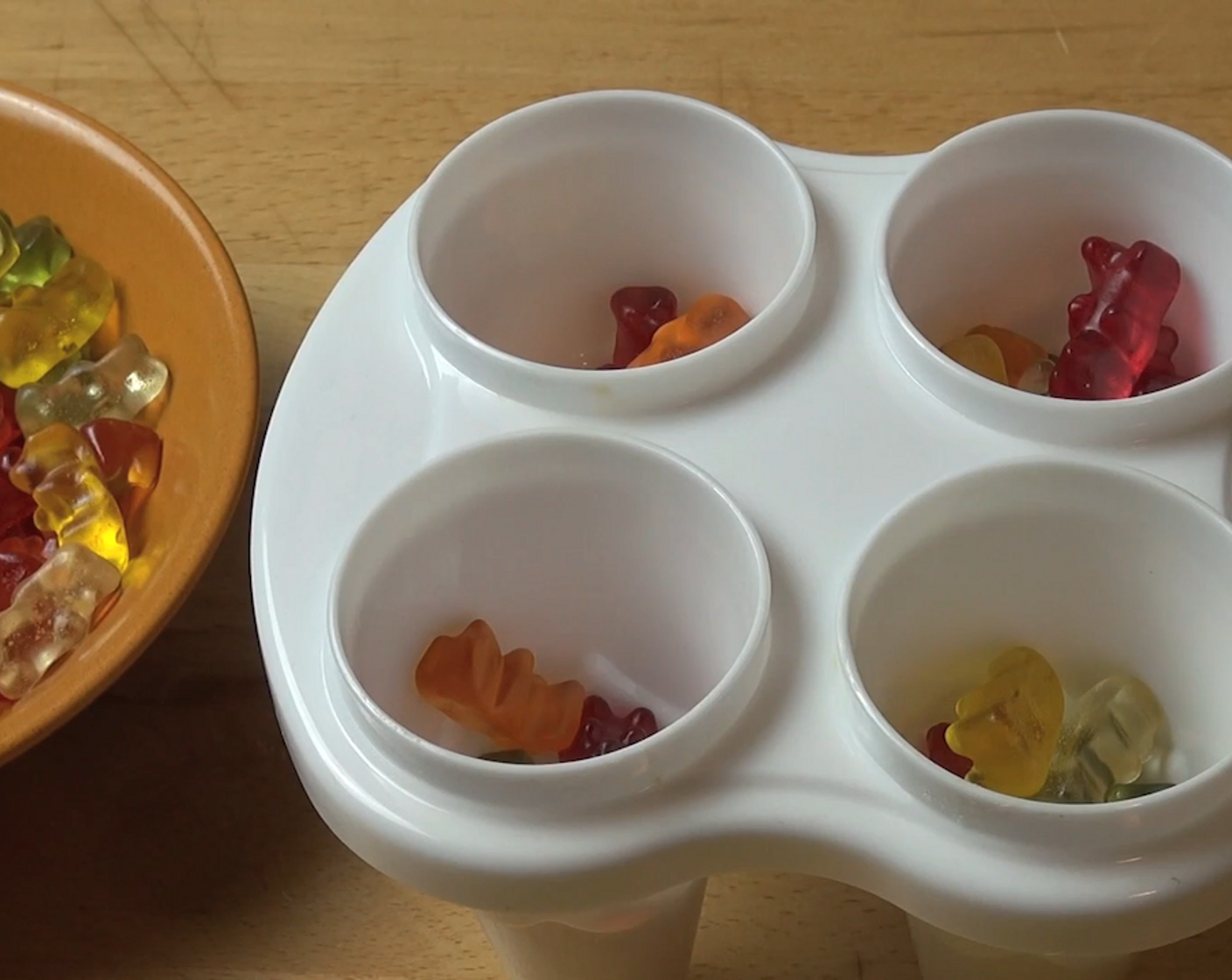 step 1 Loosely fill each cup of an ice mold evenly halfway to 3/4 way up with Gummy Bears (1/2 cup).