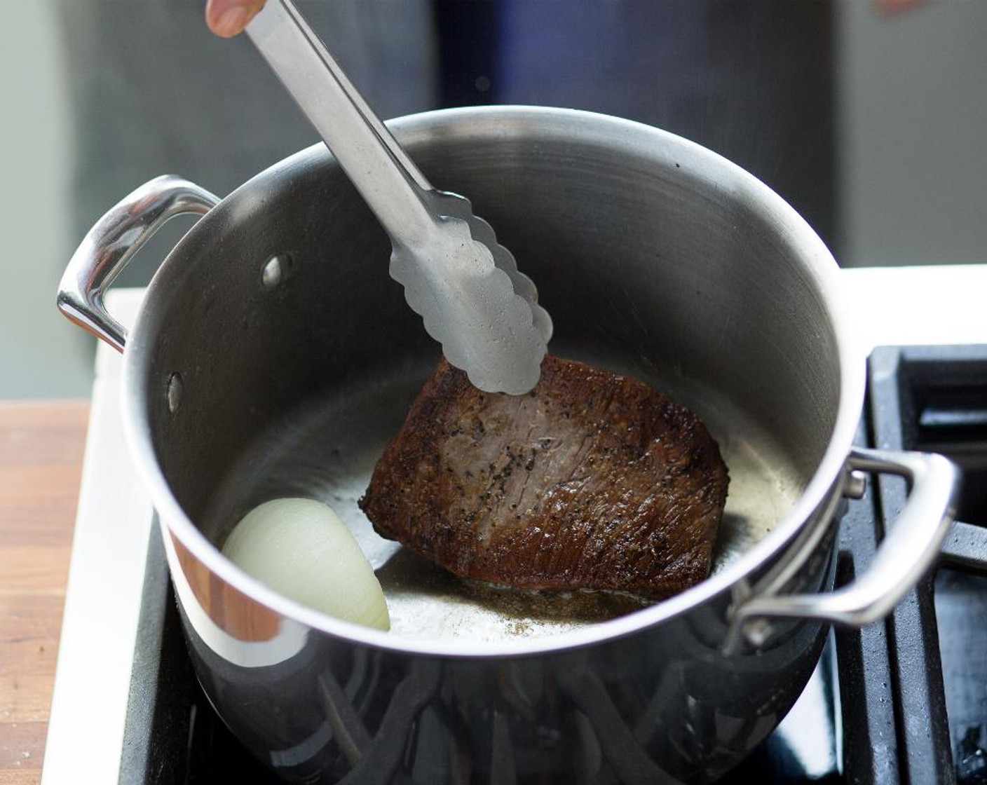 step 8 Heat a medium saucepan with Vegetable Oil (1 Tbsp) over high heat. When the oil is hot, add ginger and reserved onion half, flat side down. Add the flank steak and sear for 3 minutes on each side.