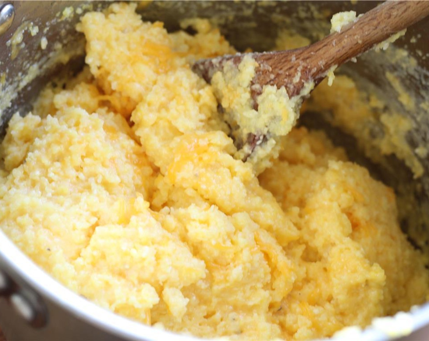 step 10 When the polenta is very stiff, stir in the Unsalted Butter (4 Tbsp) and shredded Sharp Cheddar Cheese (1 1/2 cups).
