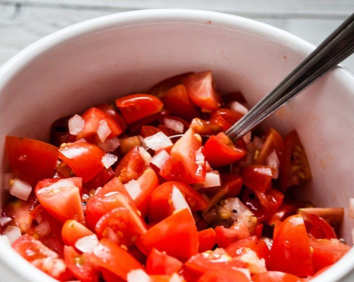 step 8 In a small bowl, combine tomatoes, two cloves of garlic, 1/4 of the onion, Salt (to taste), and Ground Black Pepper (to taste).