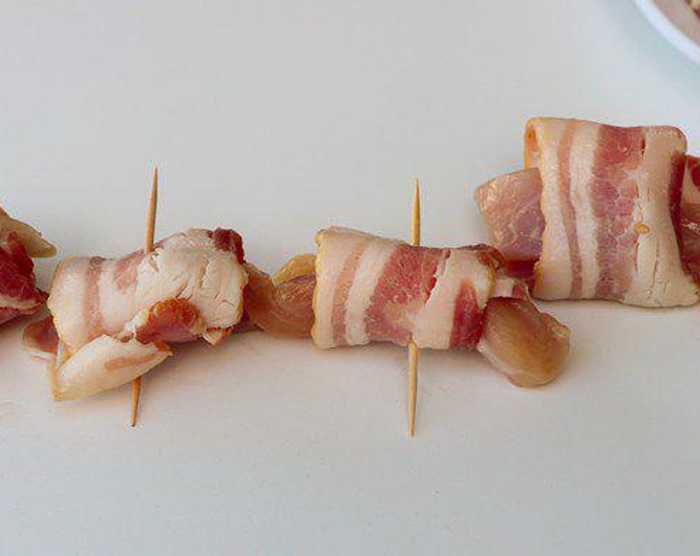 step 2 Cut each Boneless, Skinless Chicken Thigh (1 lb) into bite size portions. Wrap each piece with ½ slice of Bacon (12 slices) and secure with a toothpick.