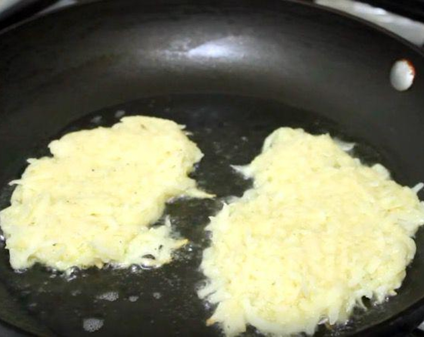 step 3 In a frying pan over medium-high heat, warm the Frying Oil (1/4 cup). Add the potato and onion mixture in small clumps, patting down to make pancake shapes. Cook for 4 minutes.