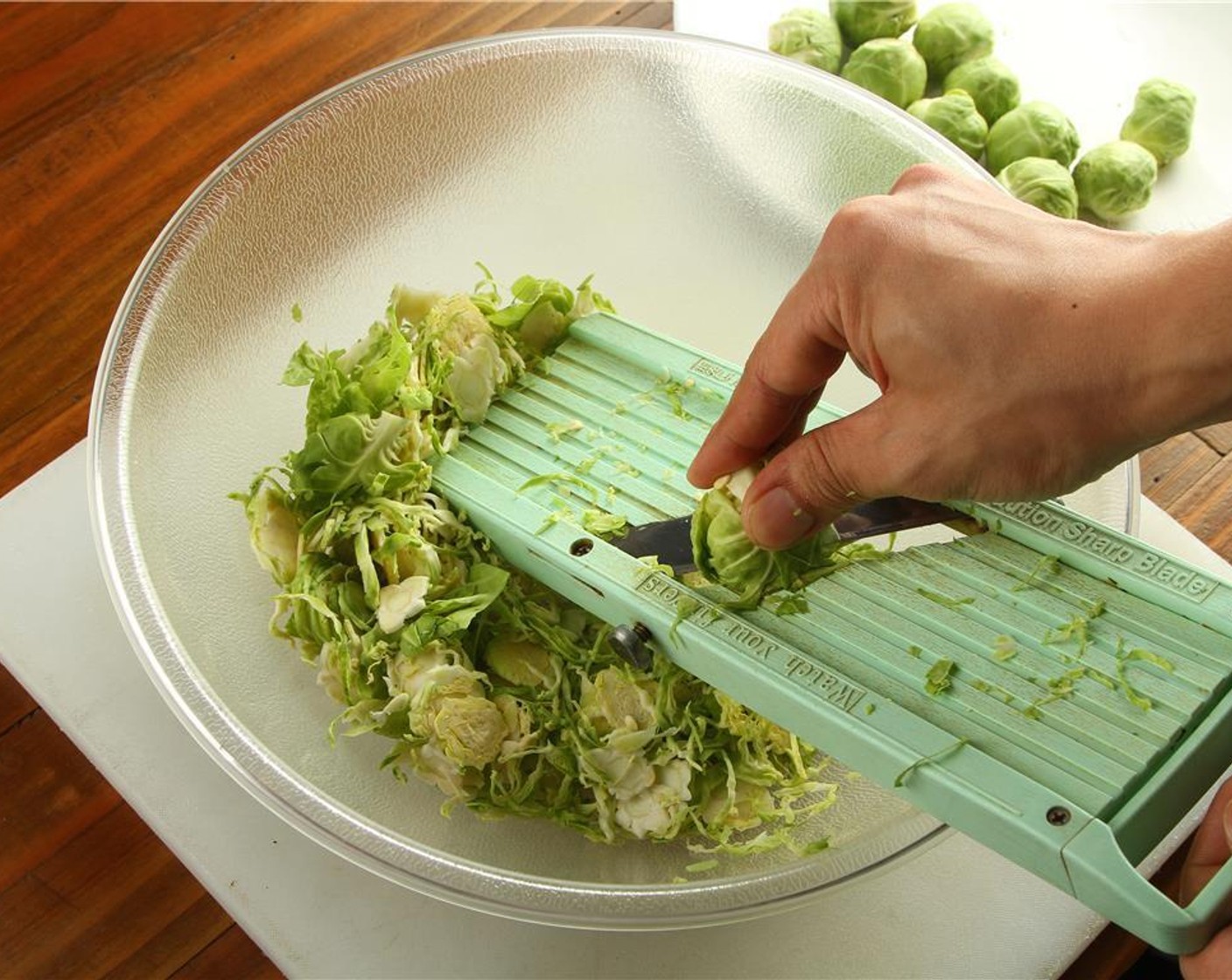 step 2 Using a mandoline, hold the brussels sprouts by the stem and thinly slice them into a large bowl. If you do not have a mandoline, hold the brussels sprouts by the stem and thinly slice them with a sharp knife.
