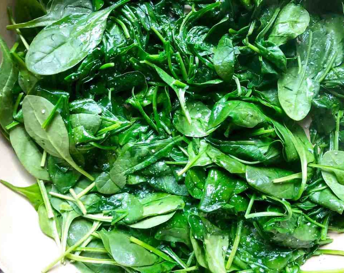 step 9 Heat 1 Tbsp of Olive Oil (1 cup) over medium heat in a large pan. Add Fresh Baby Spinach (15 cups) and season with salt and pepper. Sauté the spinach as you continuously move it around in the pan until it just begins to wilt.