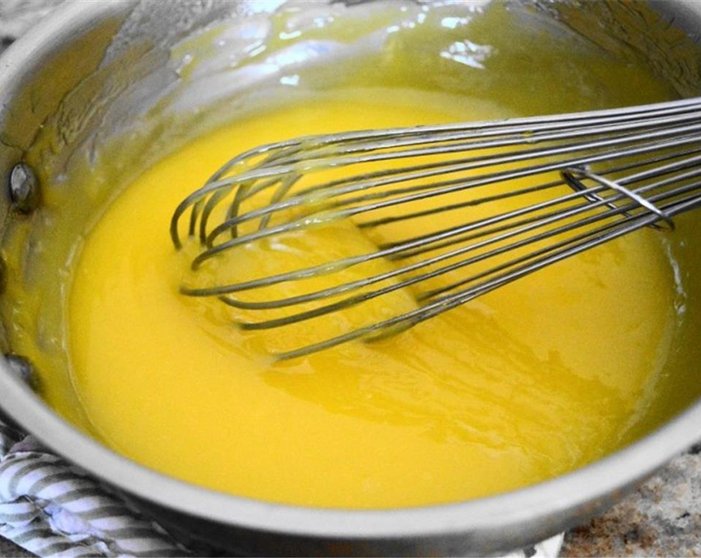 step 5 Pour the tempered eggs into the sauce pan while you whisk it into the lemon mixture. Keep whisking for about 2 minutes to let the lemon curd thicken. The mixture can bubble around the edges but do not let it come to a boil or else the eggs will scramble.