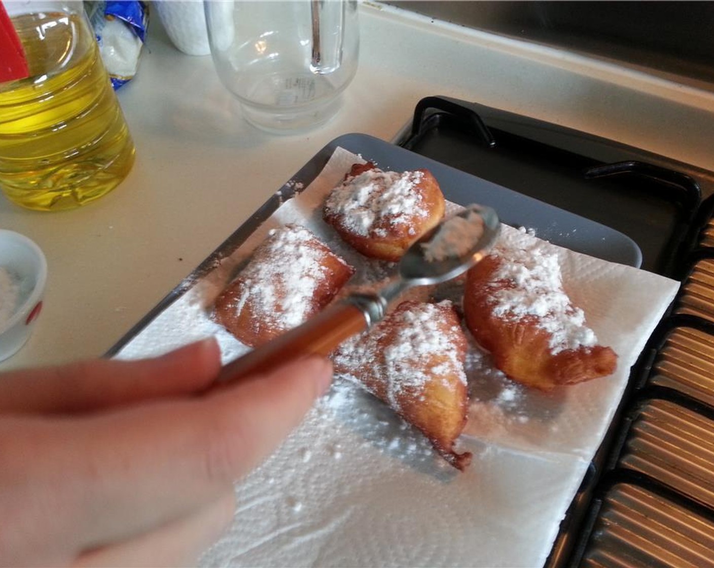step 10 After beignets are fried, drain them for a few seconds on paper towels, and then toss them into a bag with plenty of Powdered Confectioners Sugar (3 cups) or use a spoon and powder them like you're Tony Montana.