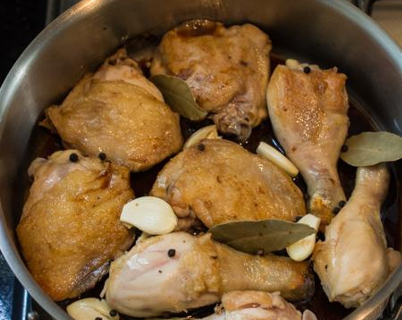 step 4 Add the Garlic (5 cloves), Bay Leaves (4), and Black Peppercorns (1 Tbsp) to the pan.