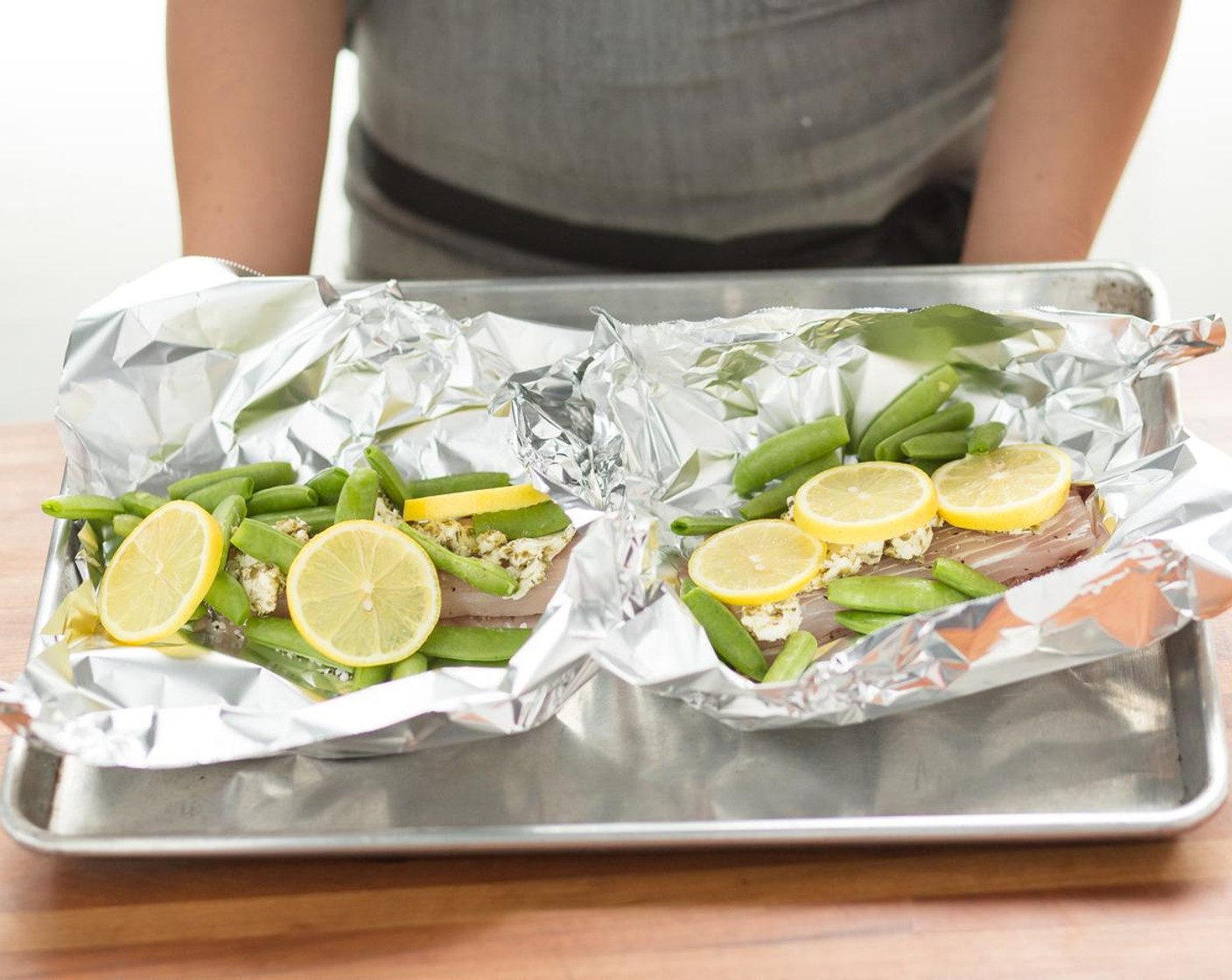 step 9 Top the lemon slices with the mahi-mahi fillets. Add another pinch of Salt (to taste) and Ground Black Pepper (to taste) then evenly distribute the caper butter between both pieces of fish.