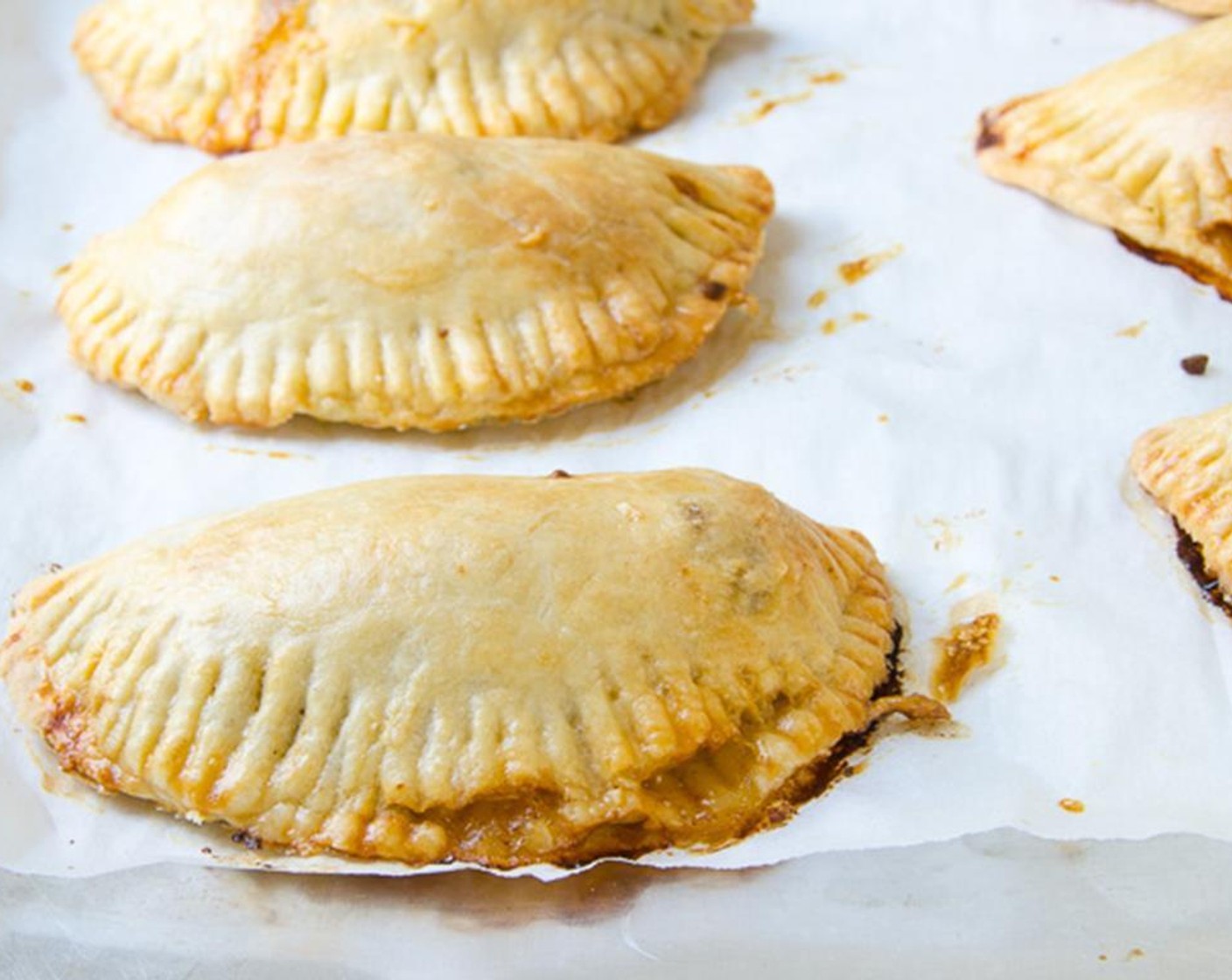 step 14 Add the Egg (1) and Water (1 Tbsp) to a small bowl and beat lightly with a fork. Use a pastry brush to paint the empanadas with the egg wash. Bake for 25 minutes, alternating the baking sheets halfway through cooking.