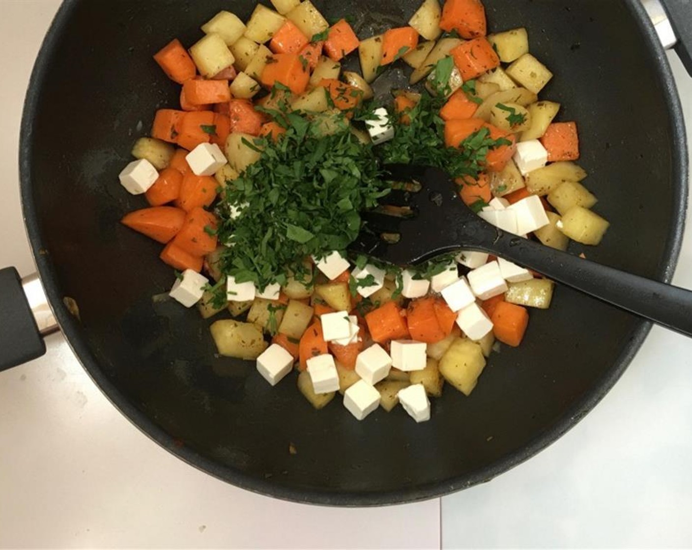 step 5 Take the pan off the heat and let the potatoes cool down. Once cooled, crumble the Feta Cheese (2/3 cup) and add it together with half of the chopped Fresh Parsley (1 handful) to the bowl.