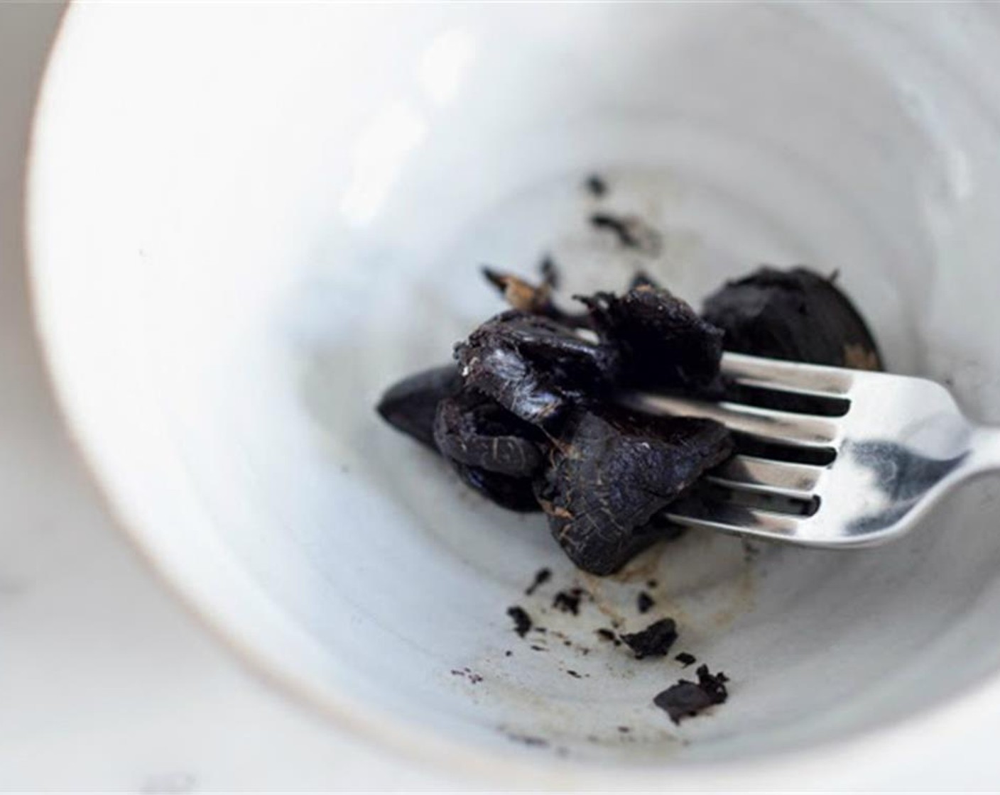 step 3 While potatoes are blanching, mash the Black Garlic (4 cloves) with Salt (1/4 tsp) and a tablespoon of Oil (1 Tbsp) it become a chunky paste.