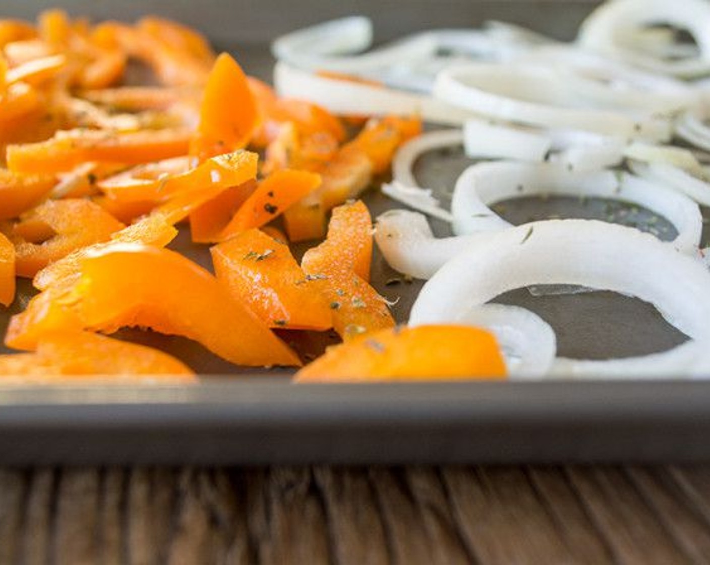 step 8 While crust bakes, add Orange Bell Pepper (3/4), Onion (1/2), and Cherry Tomatoes (5) to baking sheet and sprinkle with desired seasonings.