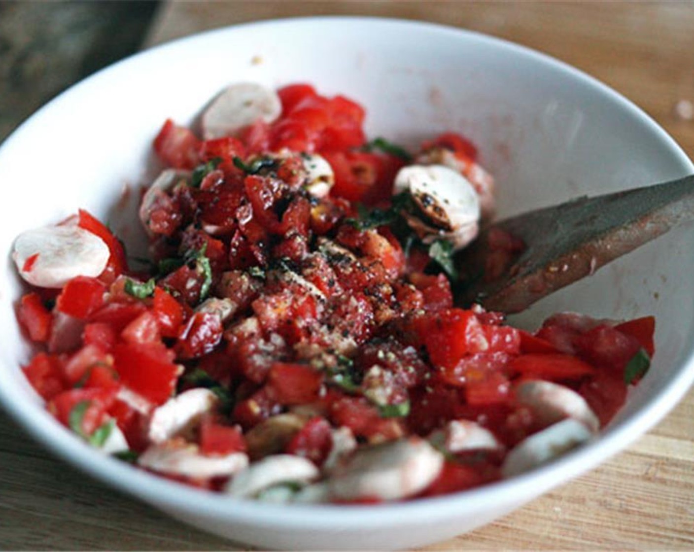 step 4 Add the diced tomatoes, mozzarella, and basil to the mixing bowl. Add the Balsamic Vinegar (1 Tbsp), Salt (1/2 tsp), and Ground Black Pepper (1/4 tsp) and mix thoroughly. Set the bowl aside while you prepare the bread.