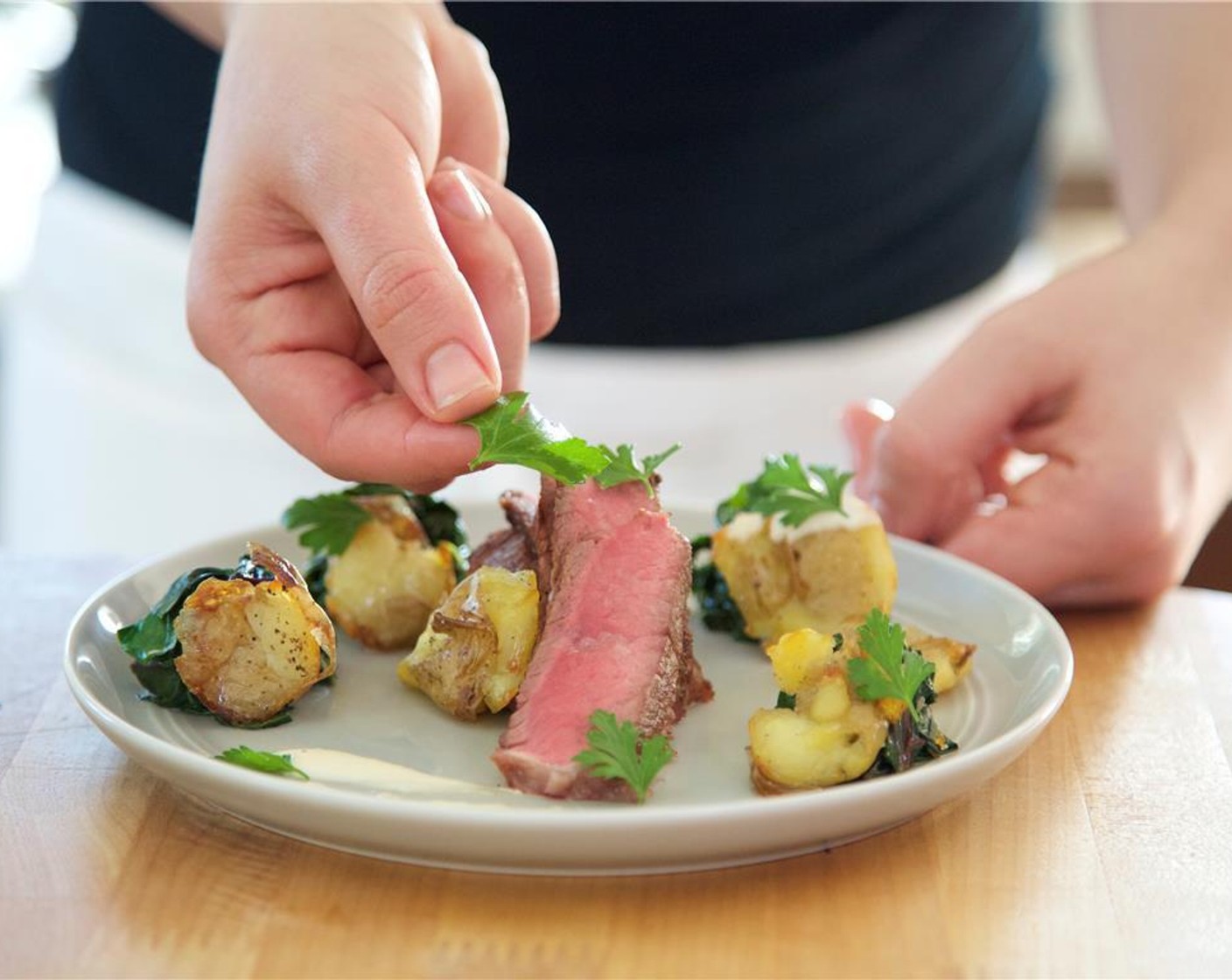 step 13 Slice steak in 10 to 12 pieces per steak, 1/4 inches thick across on the bias. Arrange the chard into several small portions around two plates. Place smashed potatoes over the chard. Swoop the horseradish sauce around the plate between the chard and over the potatoes.