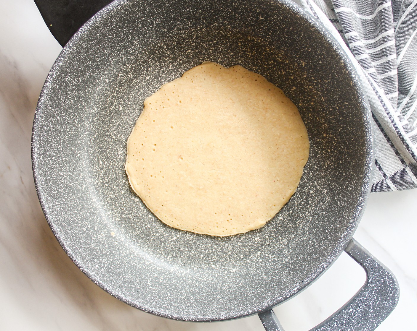 step 4 Pour in ¼ cup of batter into the pan and swirl it immediately so that the batter spreads out. Cook for about 1-2 minutes, or until the batter is fairly dry on top. Then, carefully flip it and cook it on the other side for another 30 seconds.