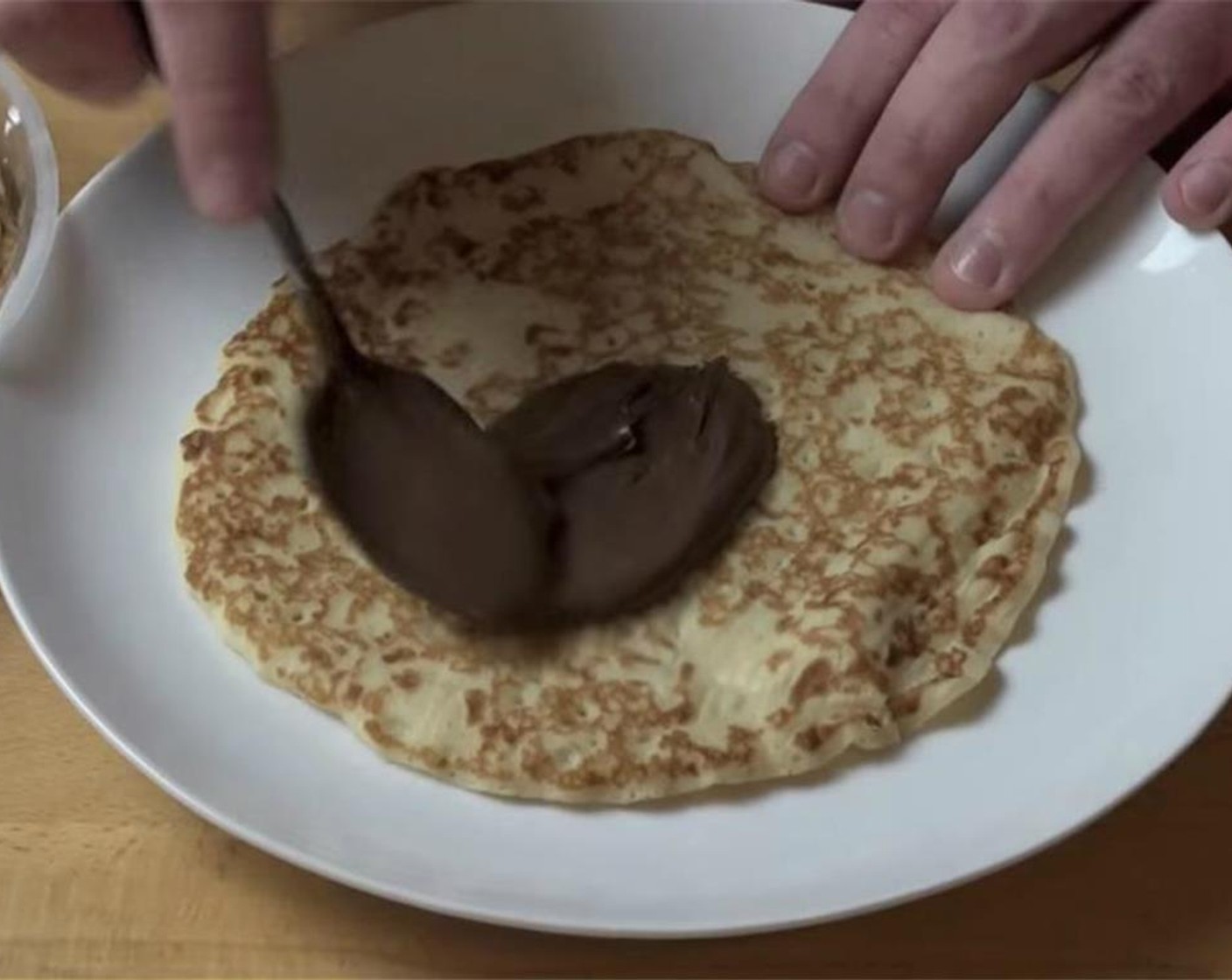 step 3 On your serving plate, place one of the Crepes (24 pieces) and dollop a tablespoon from the Nutella® (1 cup). Gently spread the Nutella with the back of a spoon.
