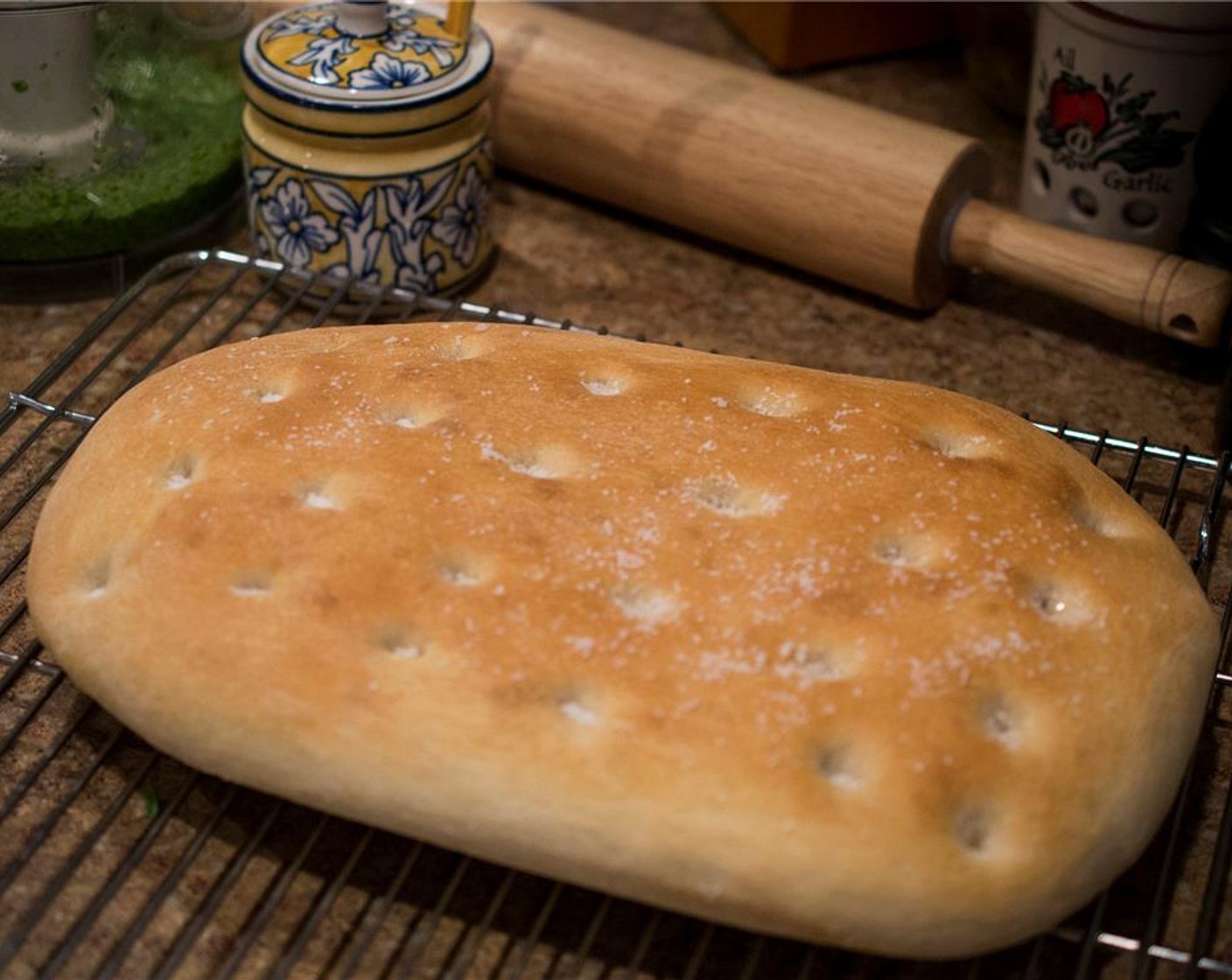 step 4 Using a sharp bread knife, slice the Focaccia Bread (1) down the middle vertically and then horizontally, creating 4 servings. Slice each section in half to create a top and bottom, and lightly brush the outside with olive oil.