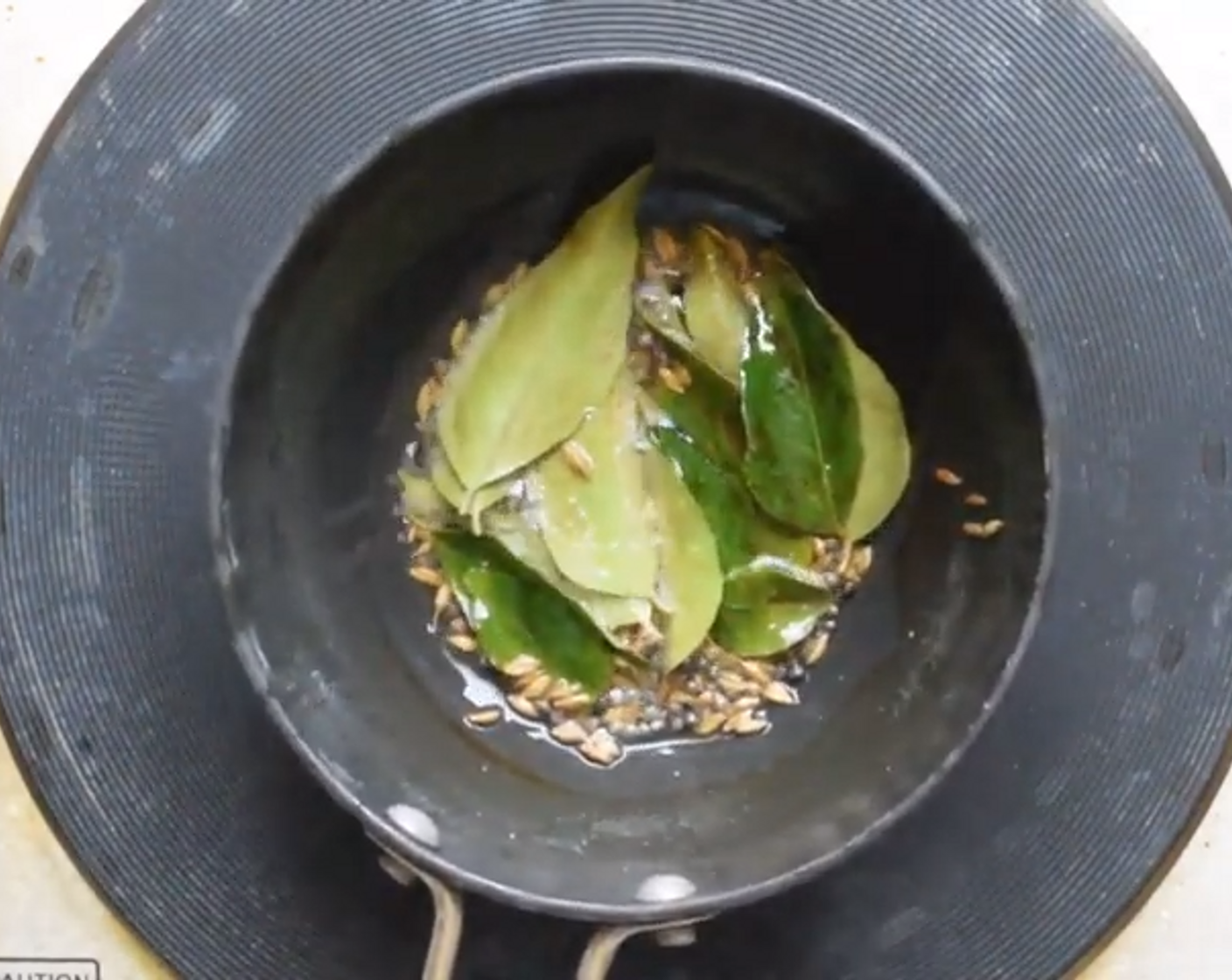 step 5 In a tadka pan, temper Mustard Seeds (2 tsp), Cumin Seeds (2 tsp), and Curry Leaves (5). Fry in Oil (1 tsp) for 30 seconds and then pour this over the batter. Mix it all together.